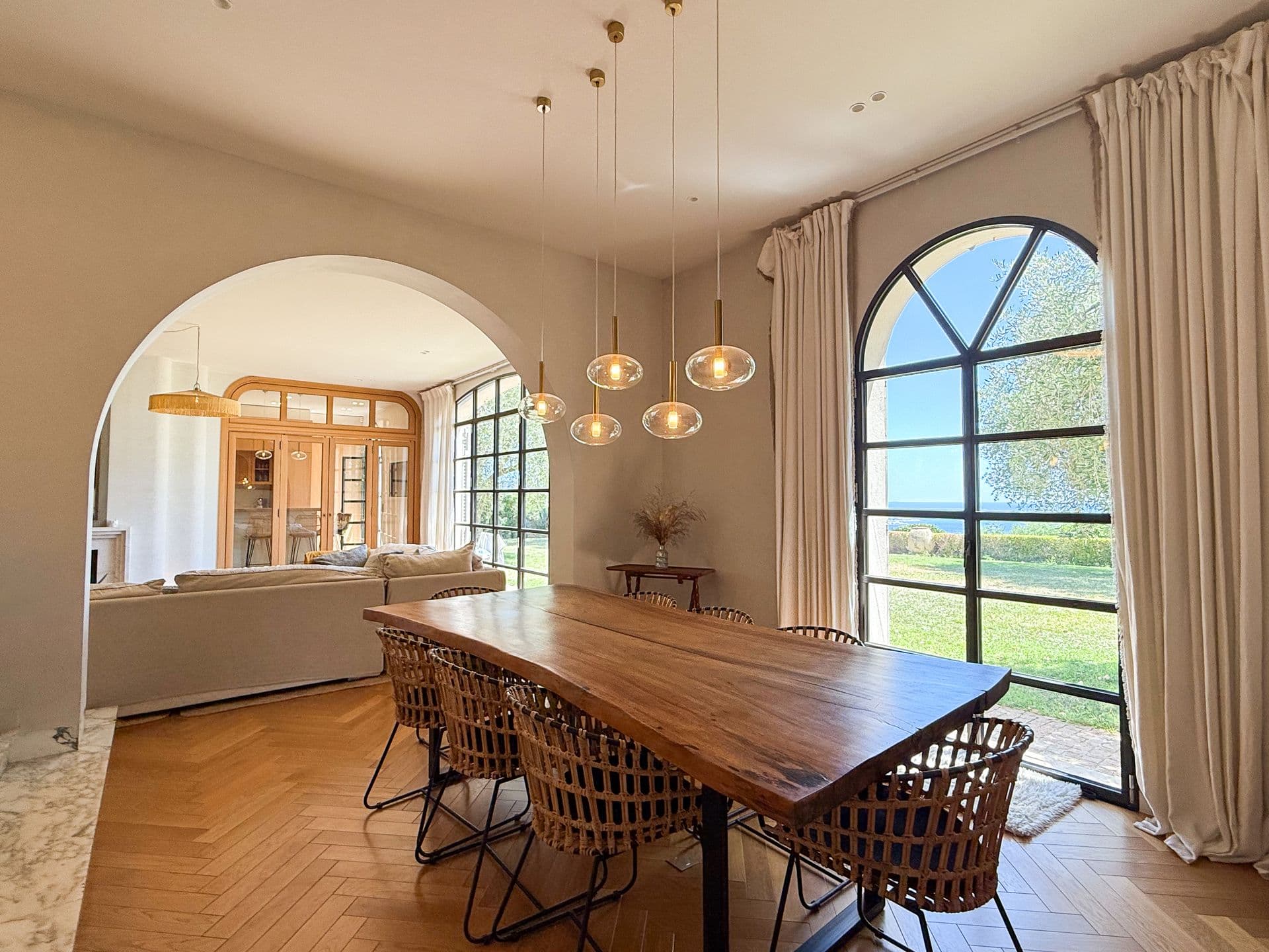 Dining room with arched sea-view windows and a pendant cluster at An Azure Vision, Cannes