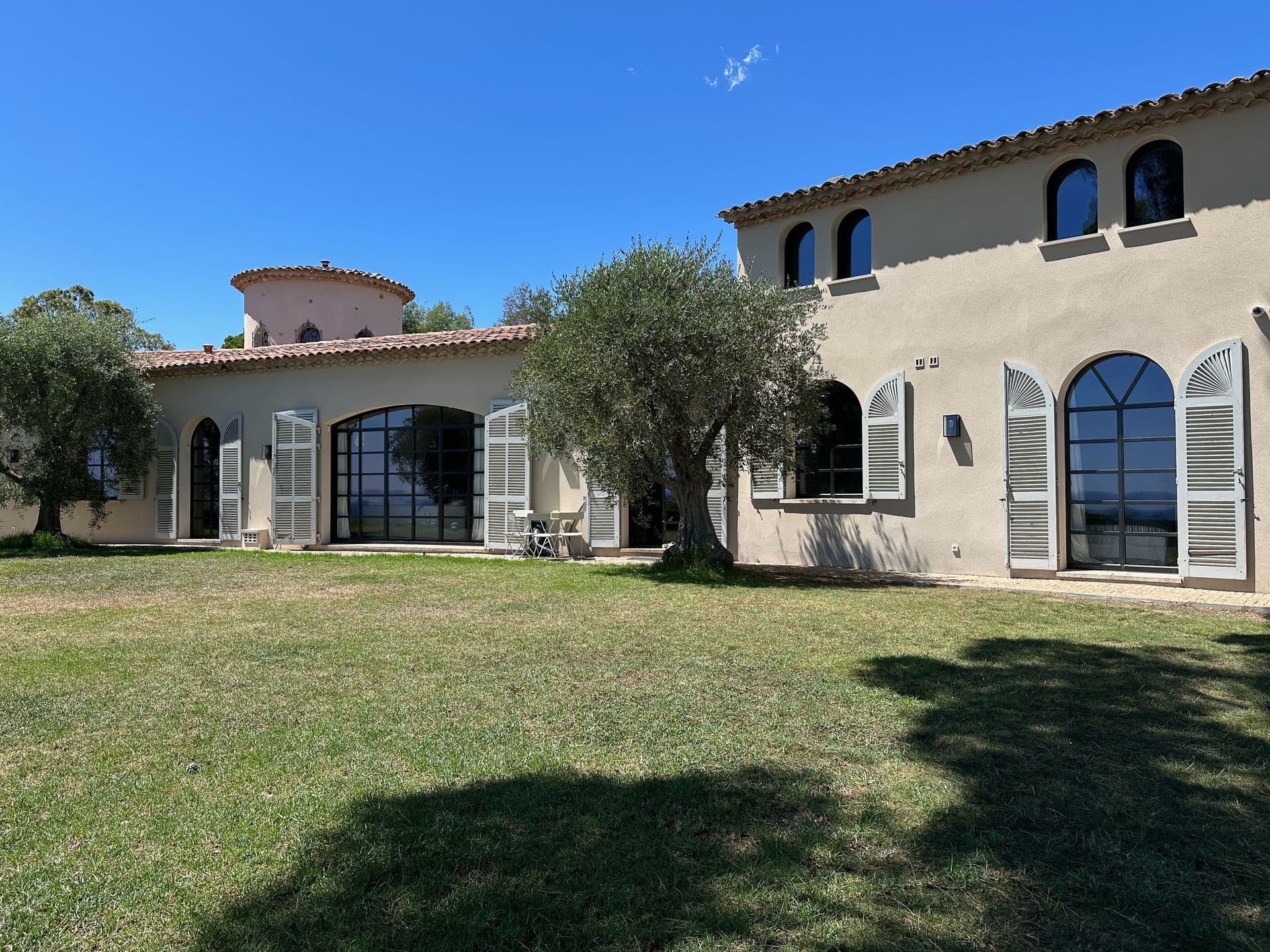 Provencal villa facade with arched windows and a lawned garden at An Azure Vision, Cannes