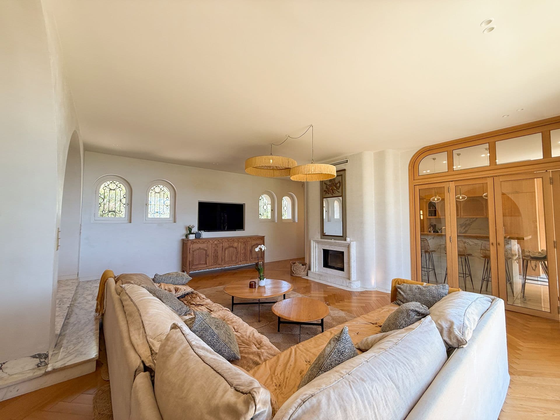 Second lounge with a television and arched windows in oak joinery at An Azure Vision, Cannes