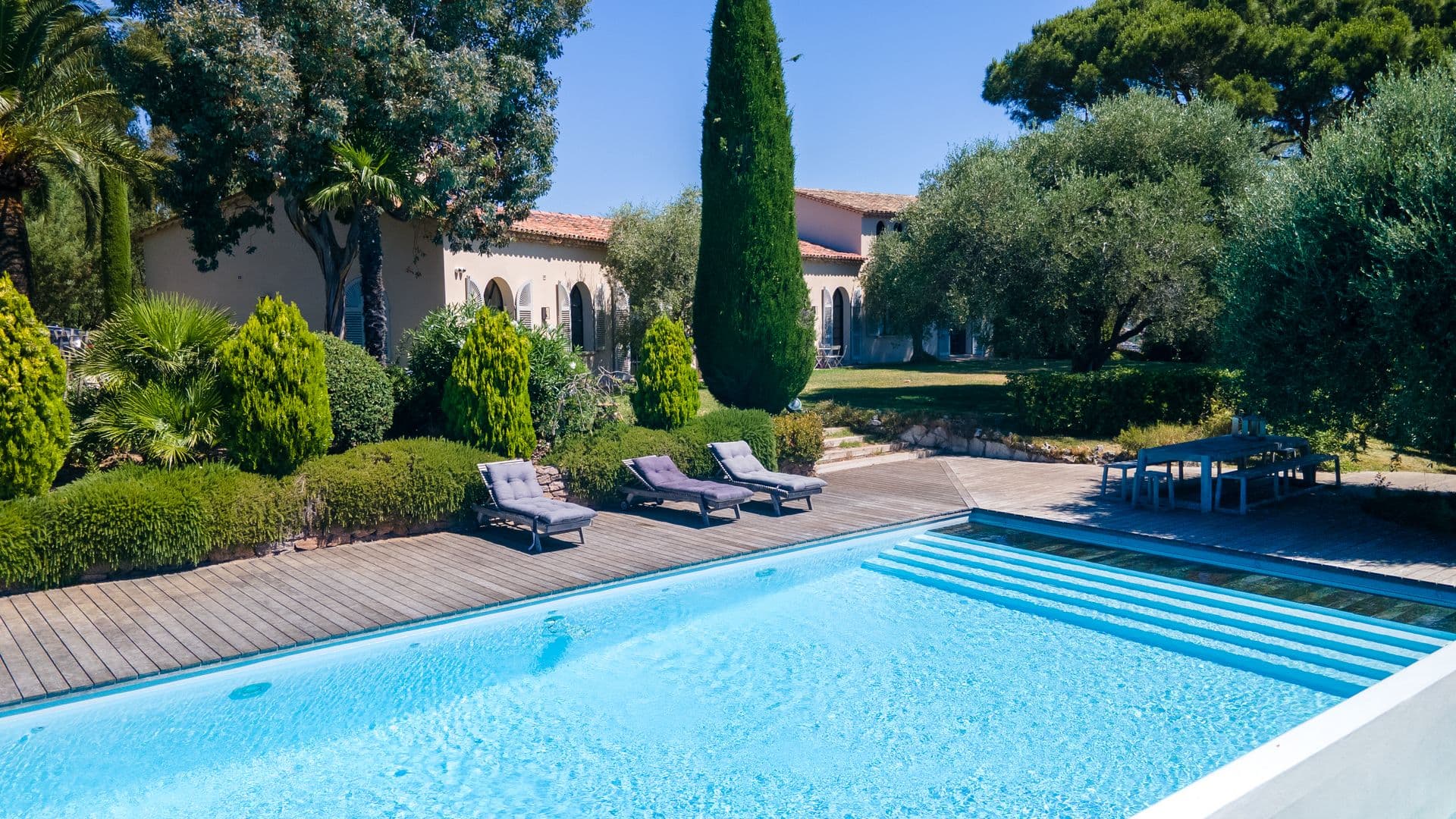Swimming pool with sun loungers beside the villa and garden at An Azure Vision, Cannes