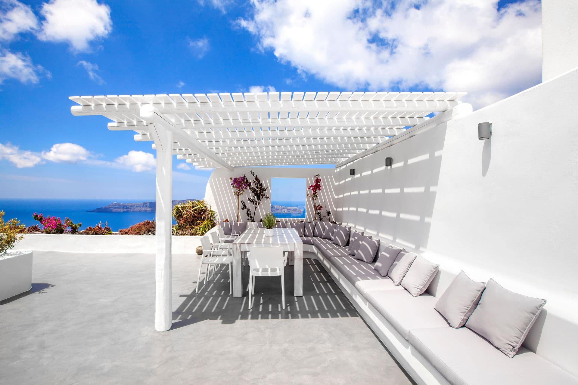 Pergola-shaded outdoor dining terrace with a built-in bench and caldera view at Cave Chic, Imerovigli, Santorini
