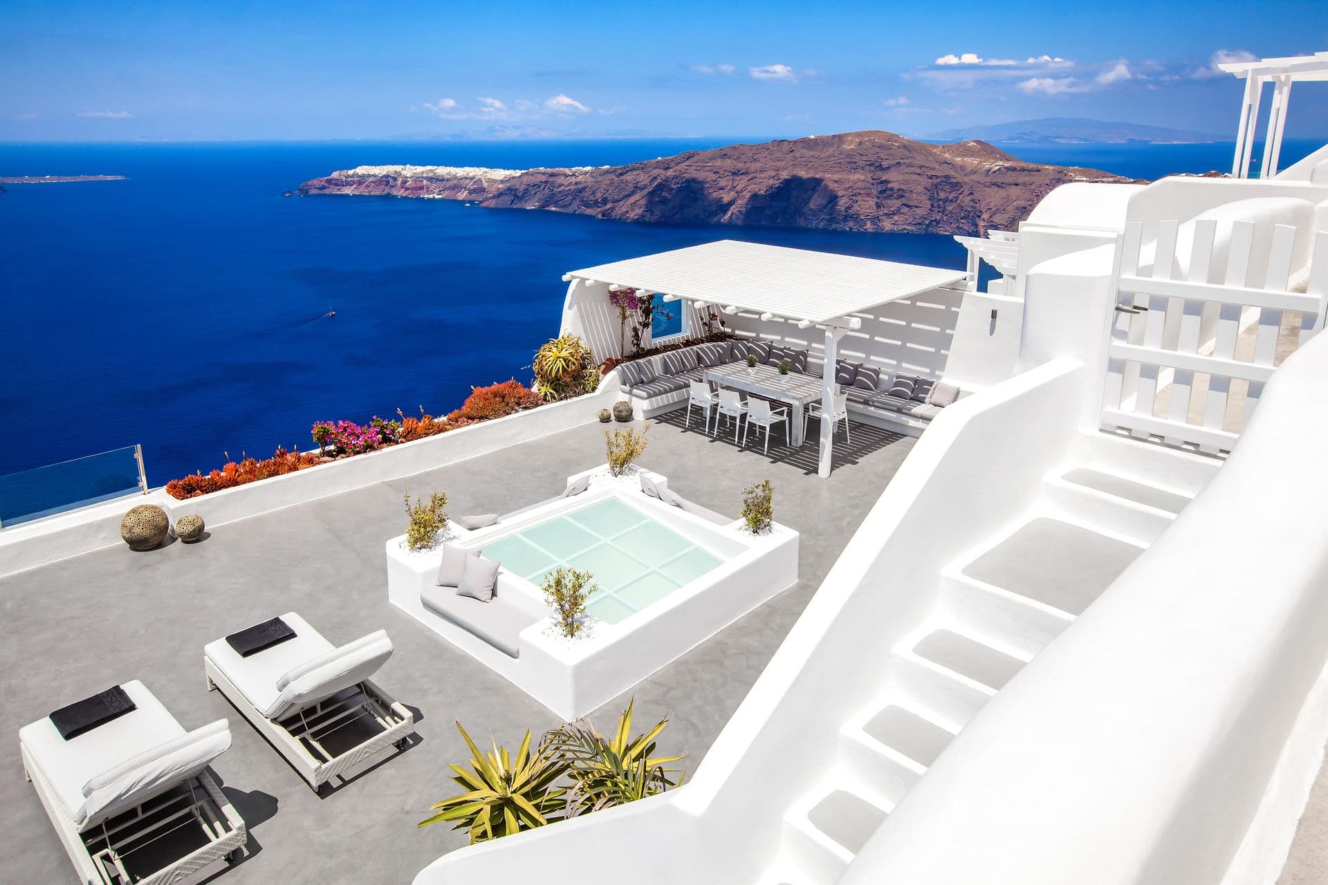White terrace with a plunge pool and loungers above the caldera at Cave Chic, Imerovigli, Santorini