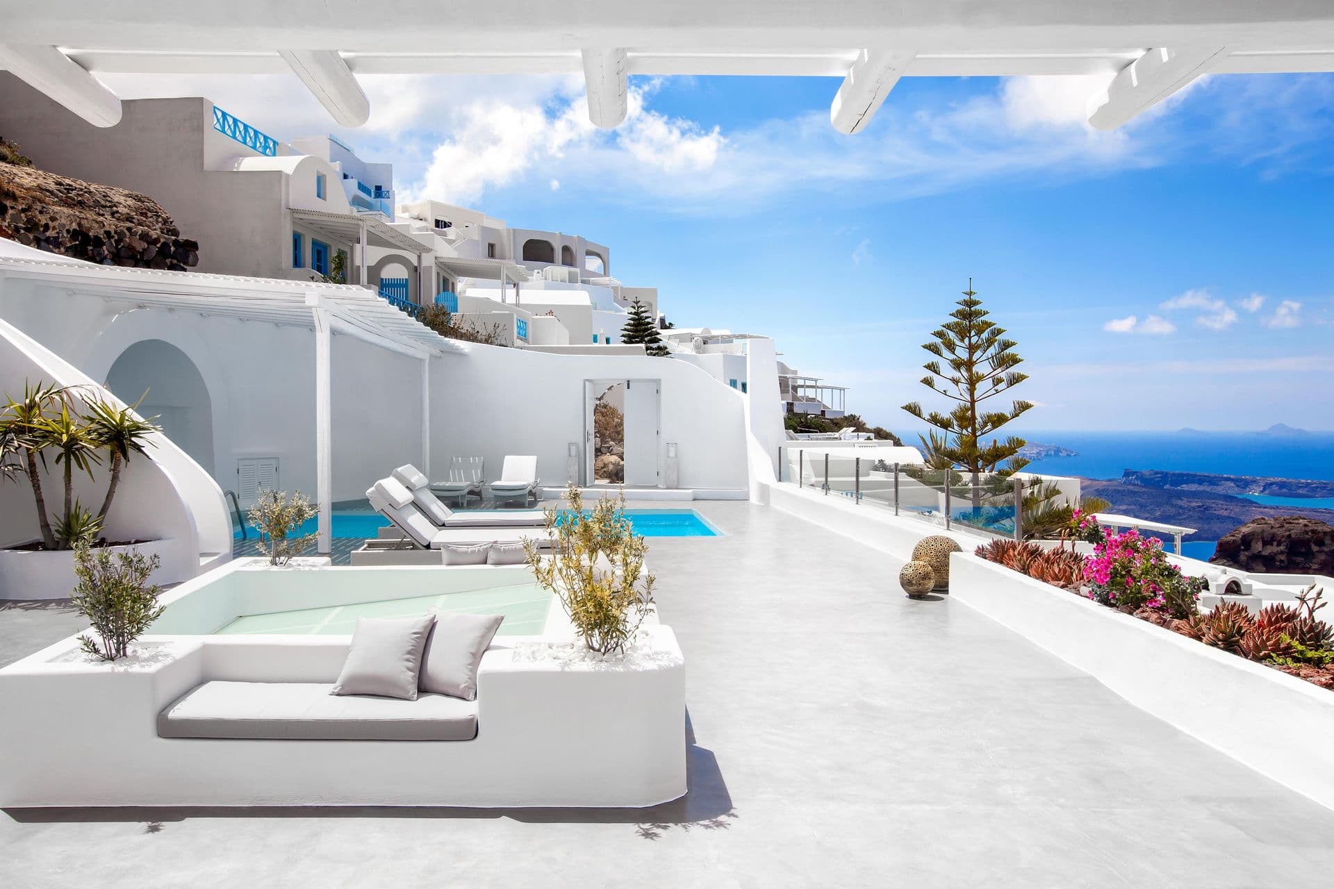 Plunge pool and day bed on a white terrace overlooking the caldera at Cave Chic, Imerovigli, Santorini