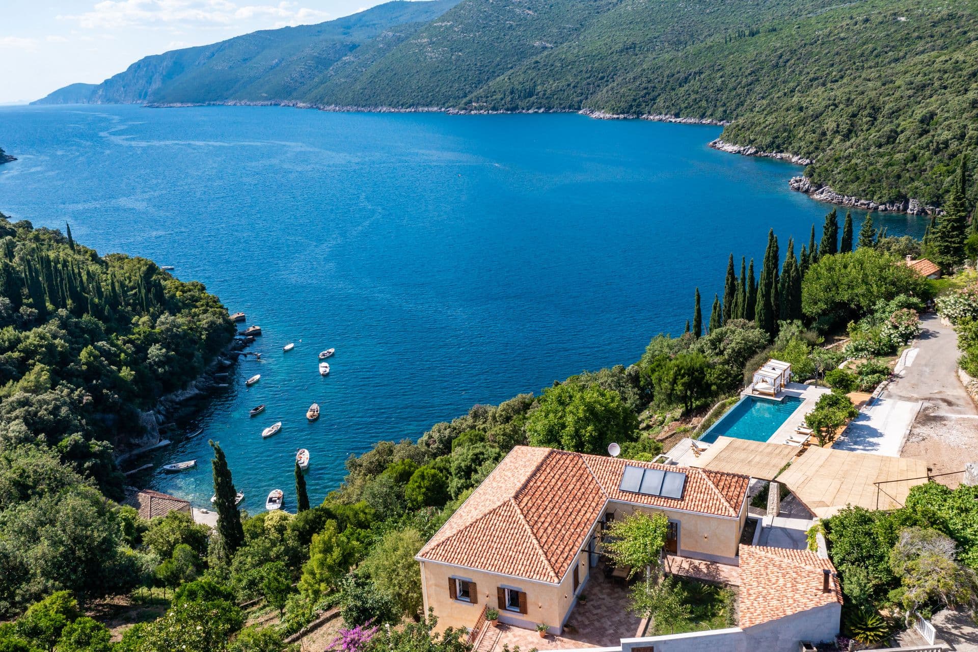 Aerial view of the villa and pool above a boat-dotted Adriatic bay at Aria to the Adriatic, Molunat, Croatia