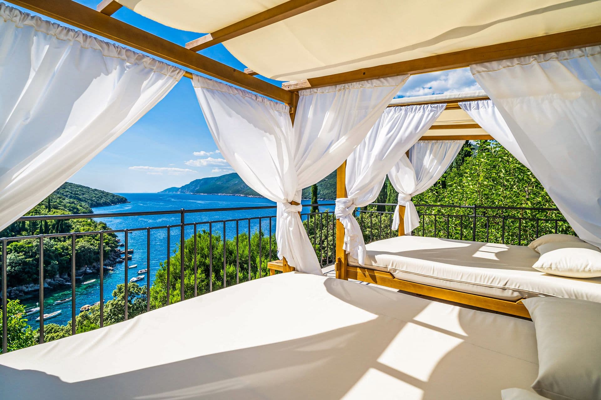 Canopied four-poster day bed on a terrace overlooking the bay at Aria to the Adriatic, Croatia
