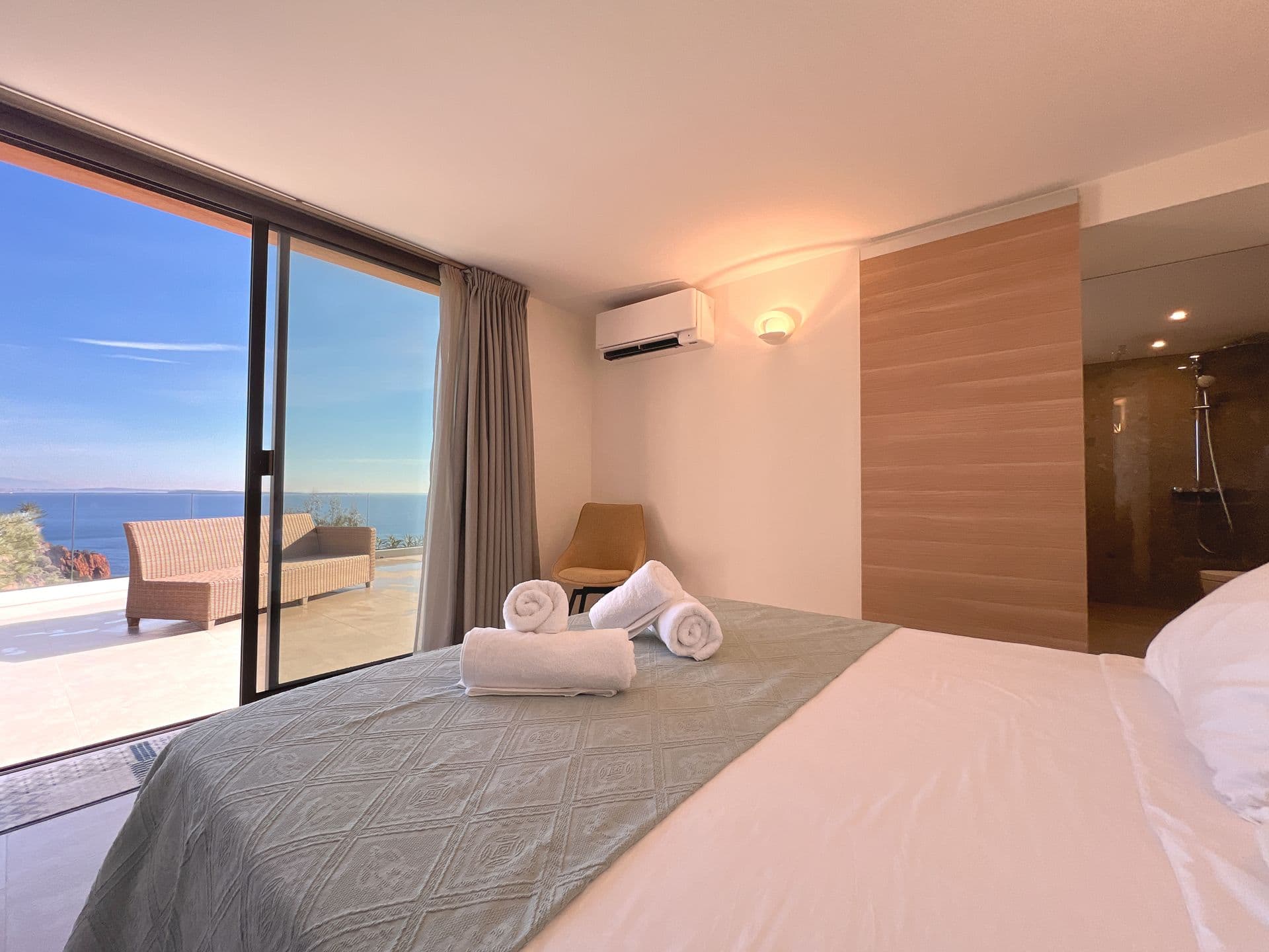 Bedroom with sliding doors opening onto a private terrace overlooking the sea
