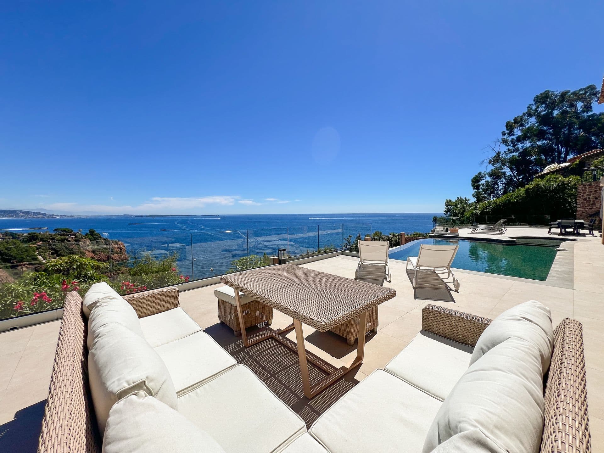 Outdoor lounge seating on the terrace with the pool and sea beyond