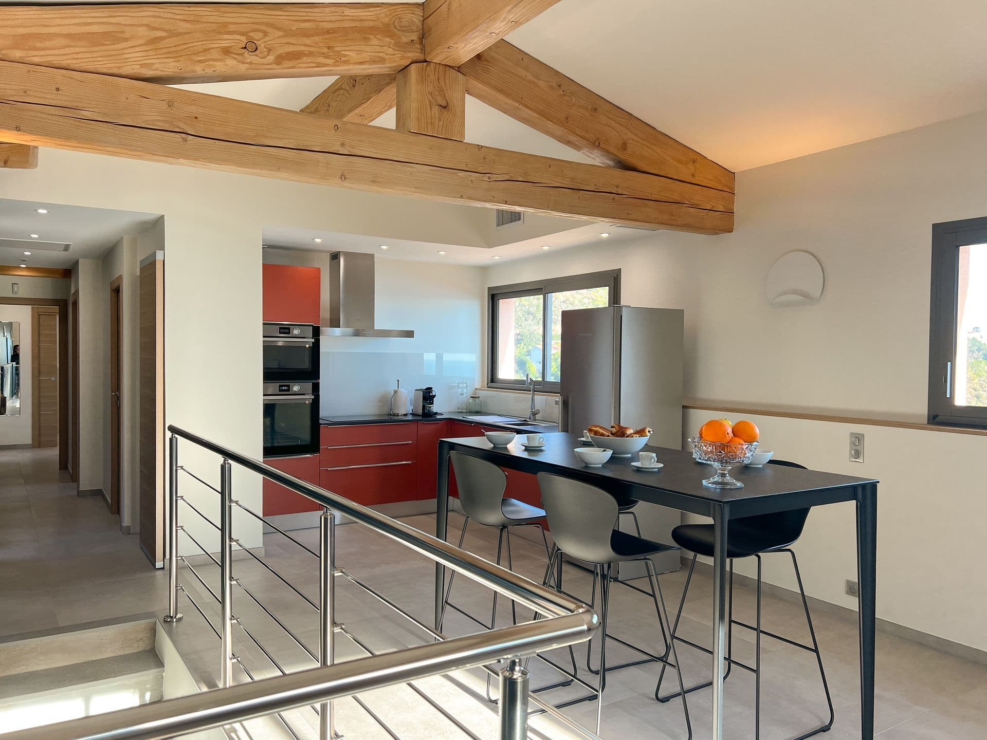 Kitchen and dining area on the mezzanine level with exposed wooden beams