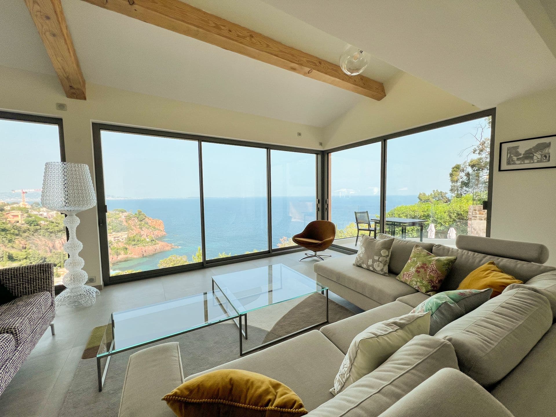 Second living area with glass coffee table and panoramic coastal windows