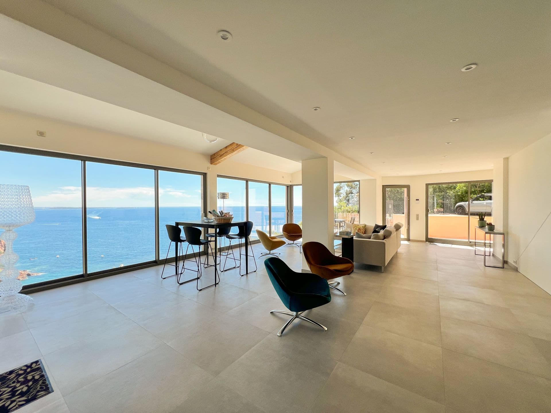 Open-plan living space with exposed timber beams and sea-facing glazing