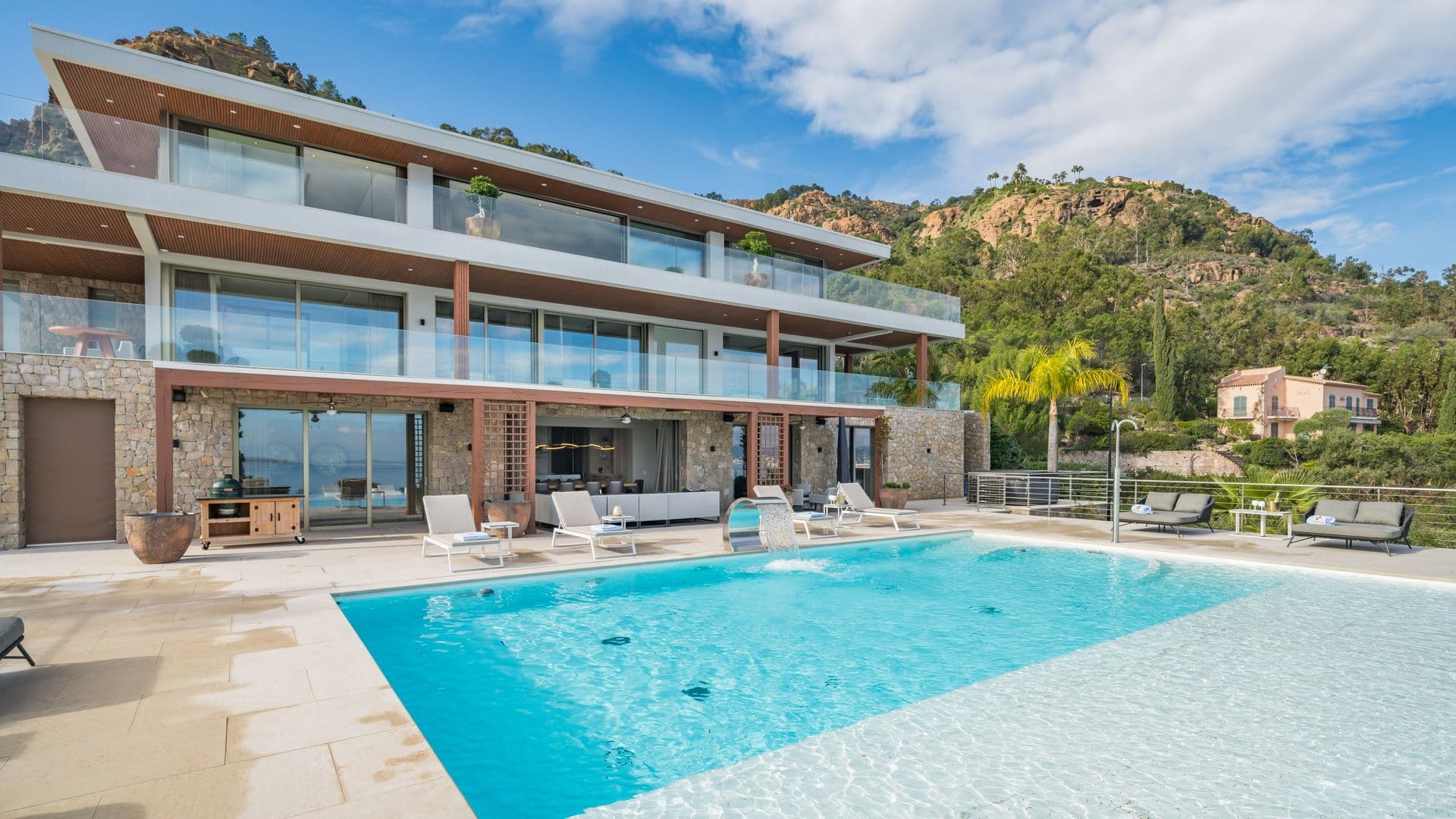 Contemporary villa facade with cantilevered upper floor above the pool terrace