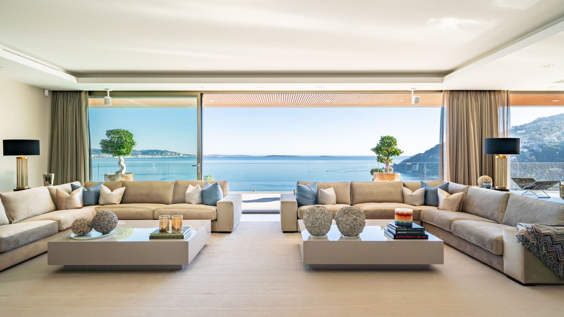 Living room with facing beige sofas and floor-to-ceiling terrace doors