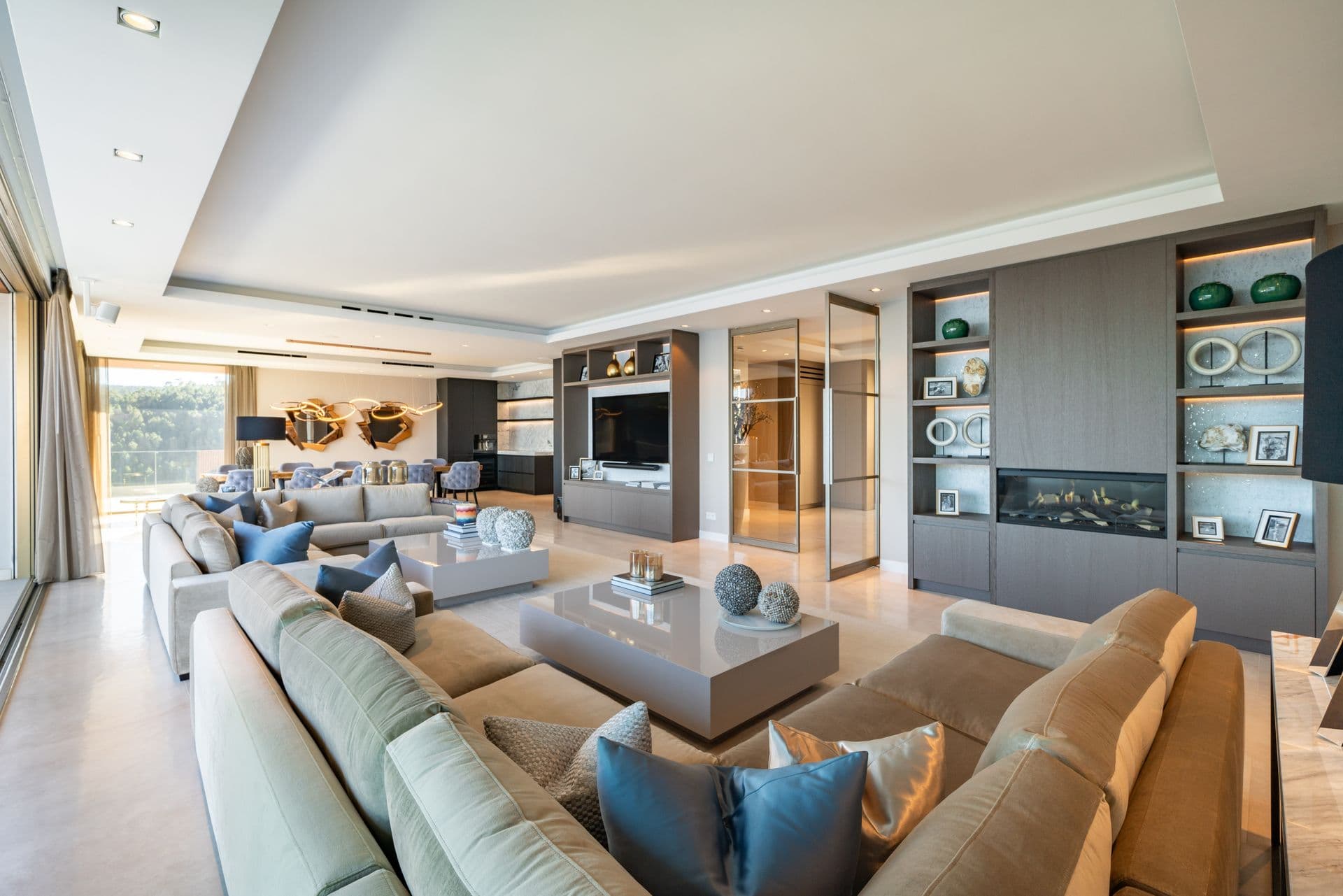Second living room with grey sectional sofas and a wall-mounted television