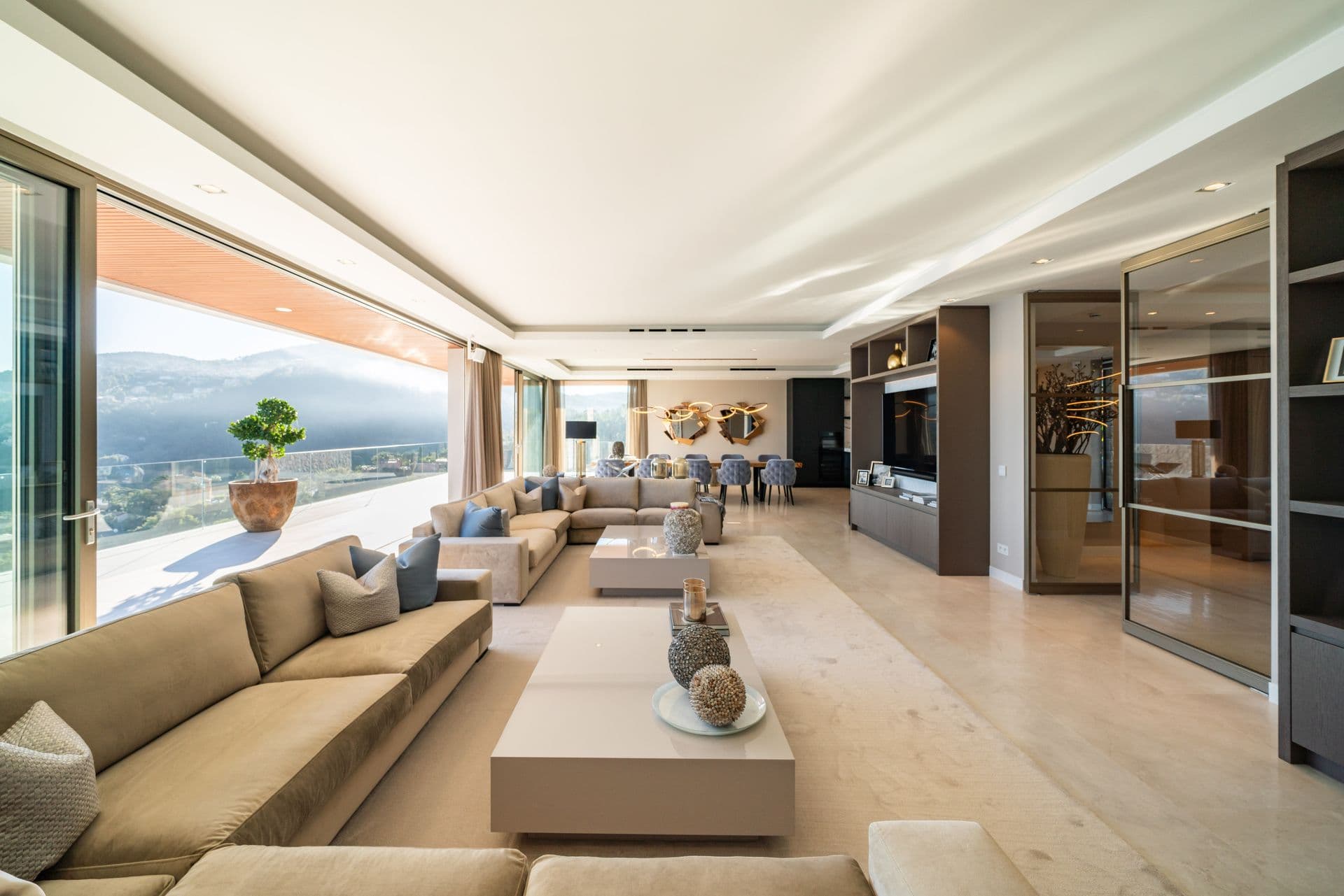Living room seating arranged around a low table with sea views beyond
