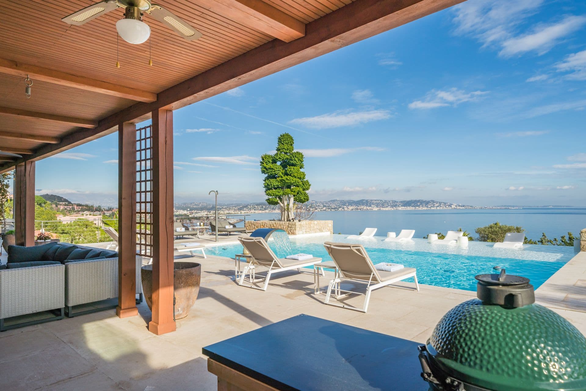 Poolside terrace with outdoor grill station and panoramic sea view