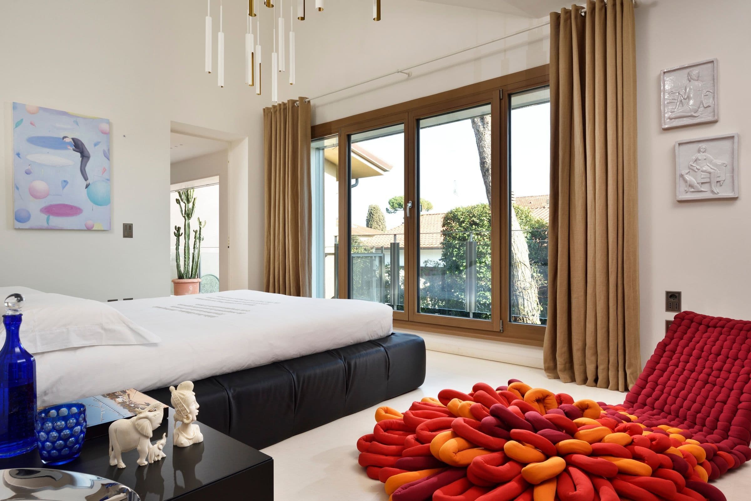 Villa Oblò master bedroom with pendant lighting and balcony, Forte dei Marmi, Tuscany, Italy
