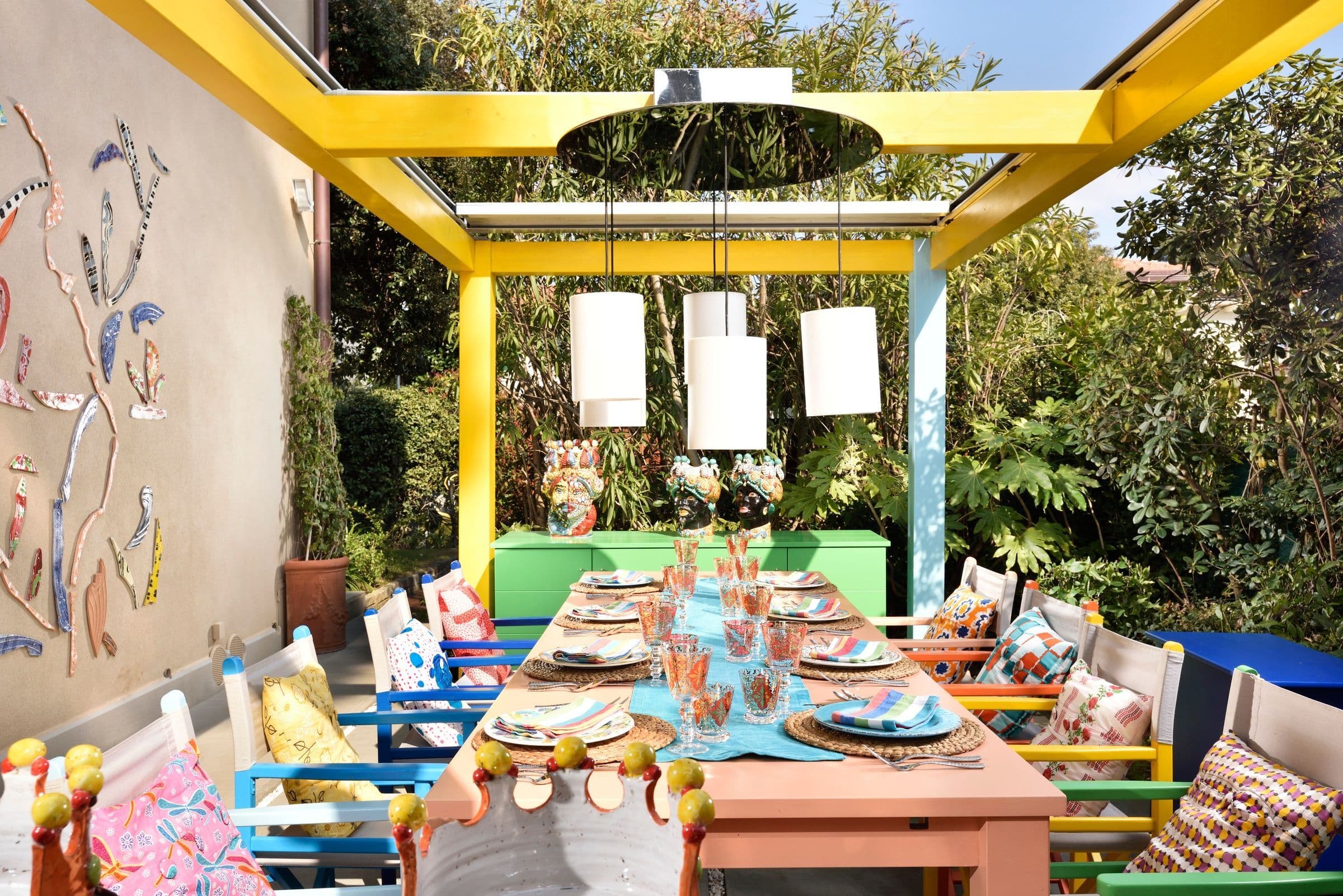 Villa Oblò outdoor dining with yellow pergola and painted furniture, Forte dei Marmi, Tuscany, Italy
