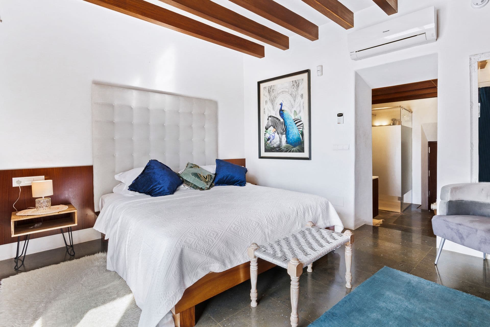 Bedroom with navy bedding and artwork at Ode to Balearic Sunsets, Ibiza