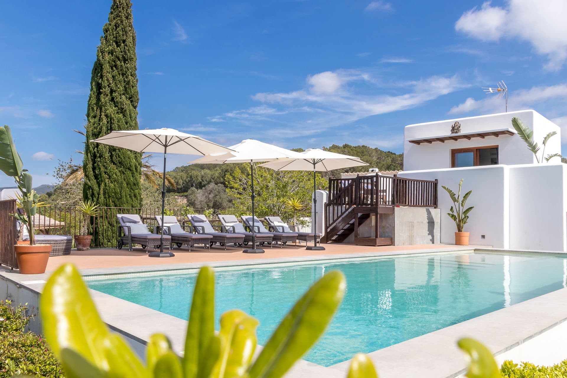 Pool terrace with sun loungers and umbrellas at Ode to Balearic Sunsets, Ibiza