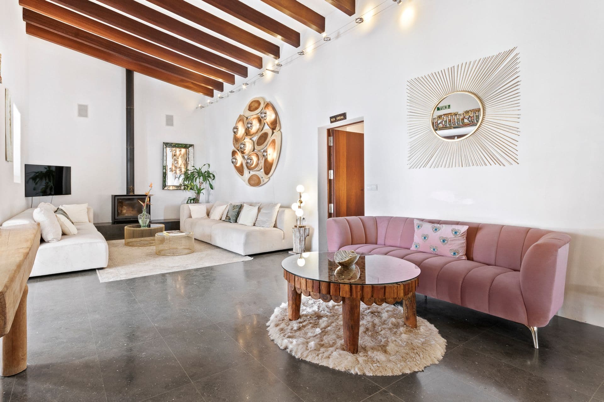 Living room with pink accent sofa and rustic beams at Ode to Balearic Sunsets, Ibiza