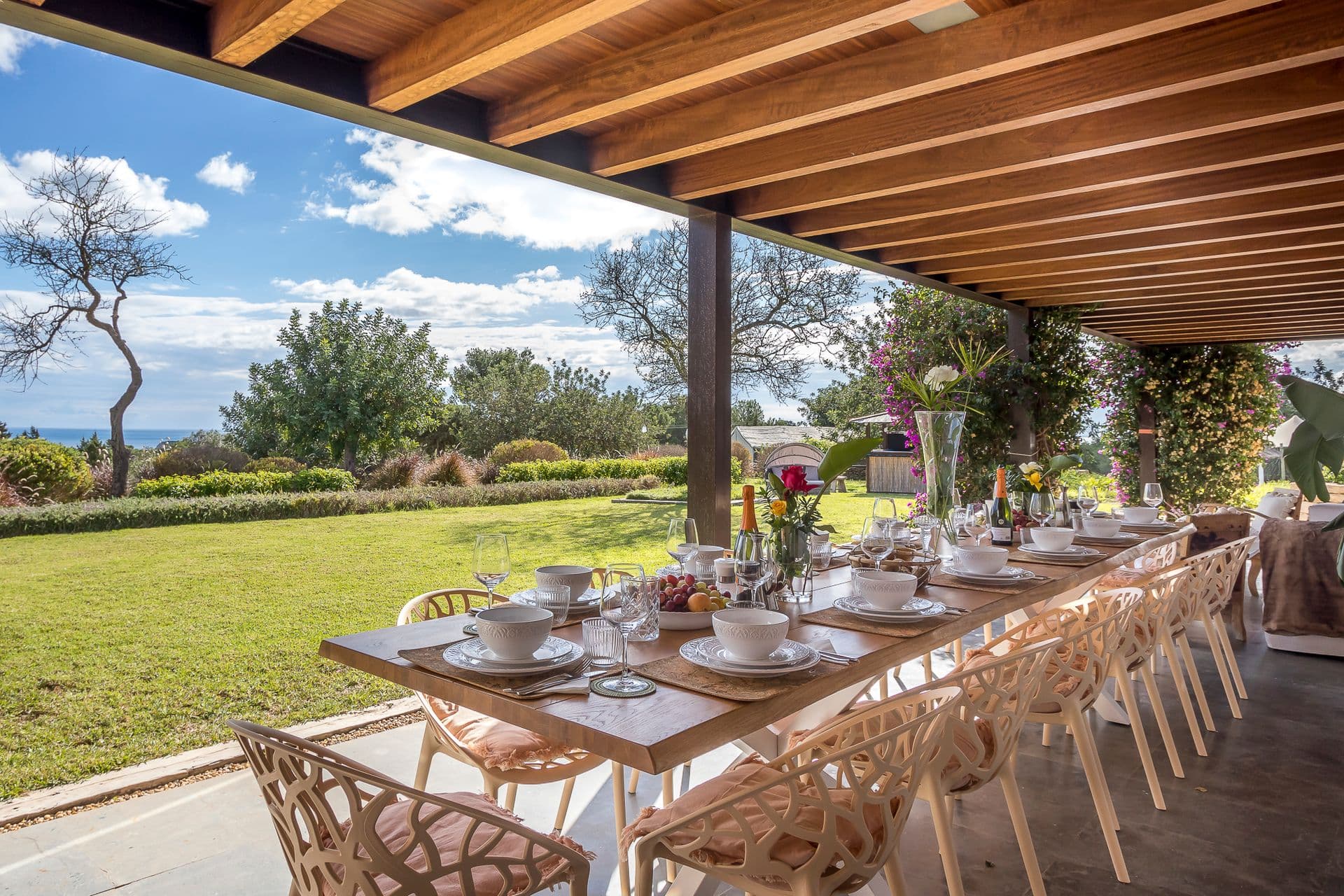 Long outdoor dining table beneath a pergola at Ode to Balearic Sunsets, Ibiza