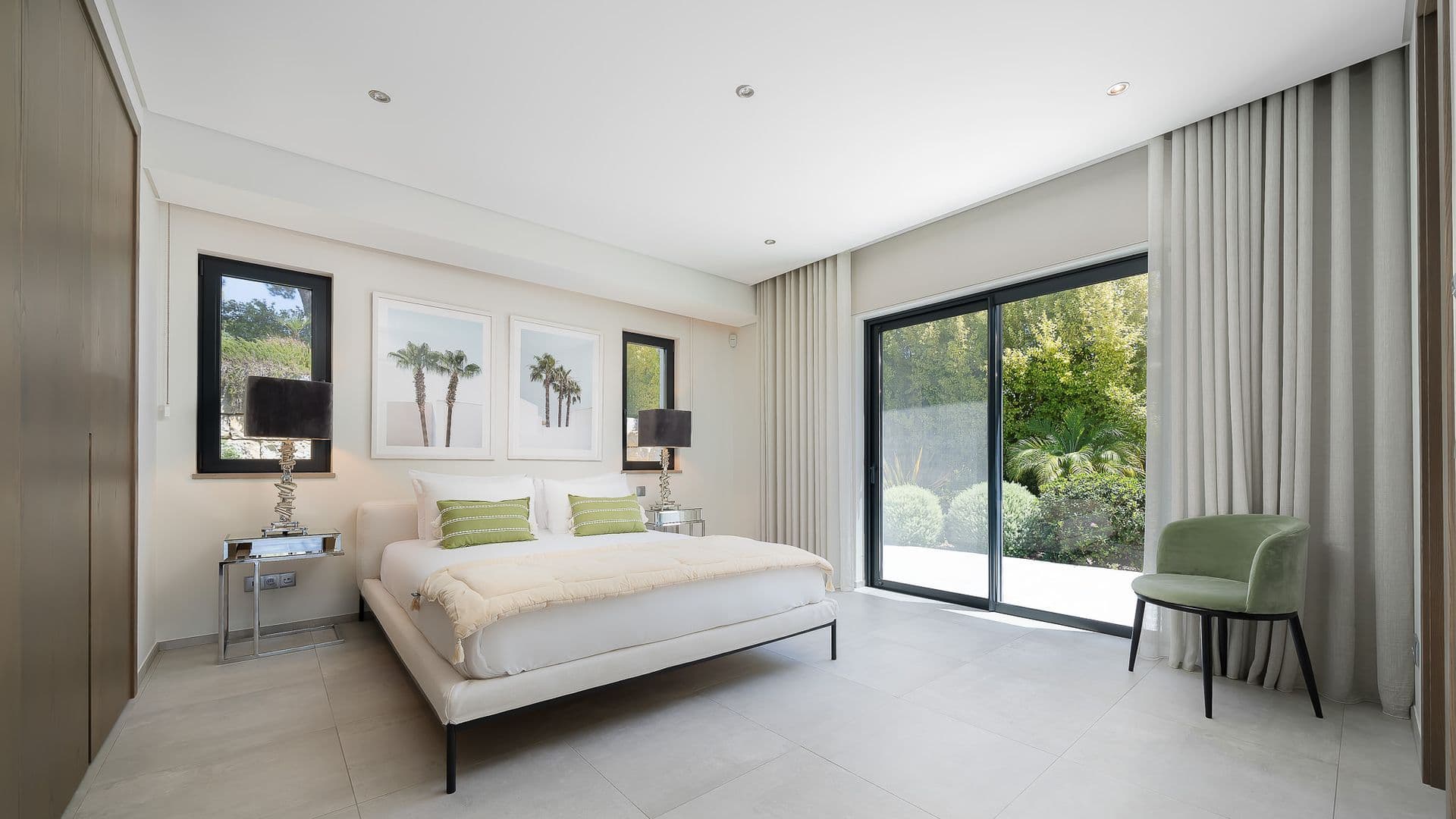 Bedroom in neutral tones with sliding doors opening onto the garden