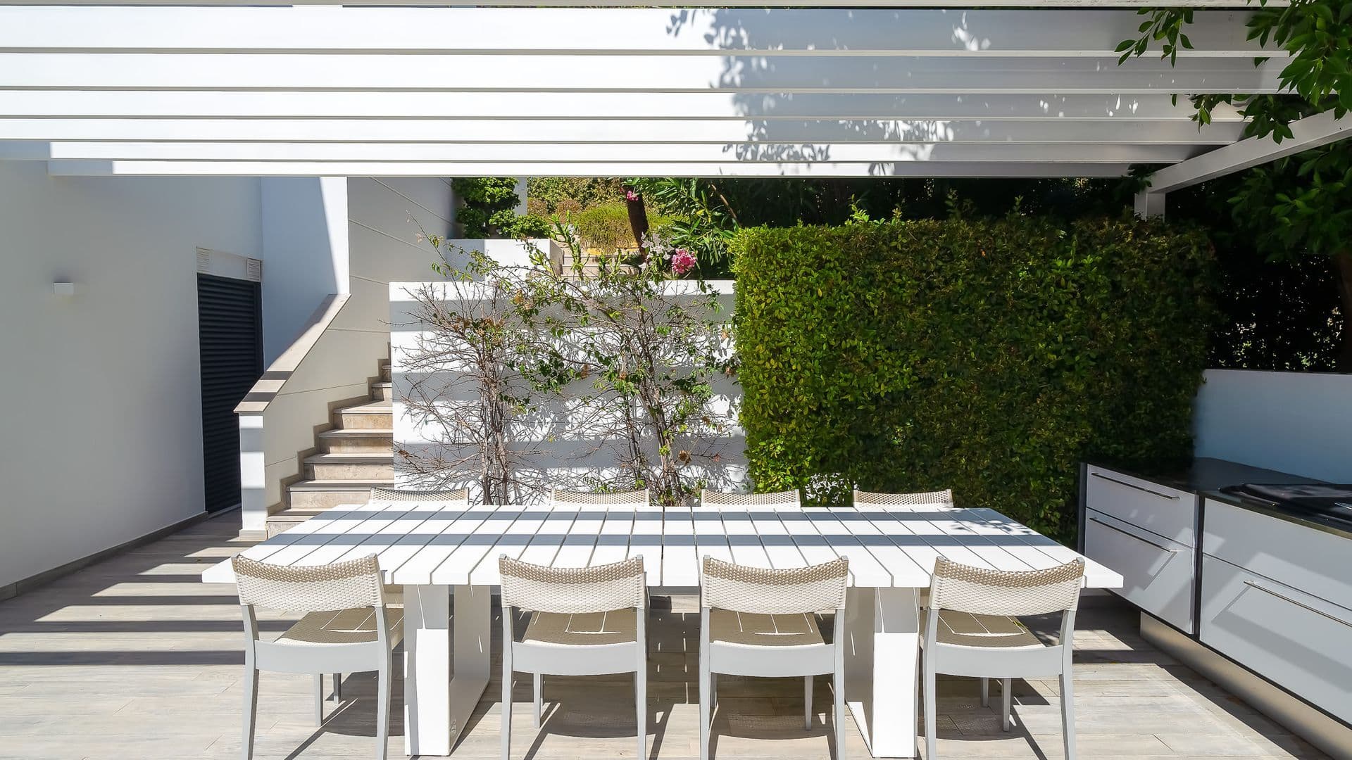 Outdoor dining table for eight set on a stepped stone terrace