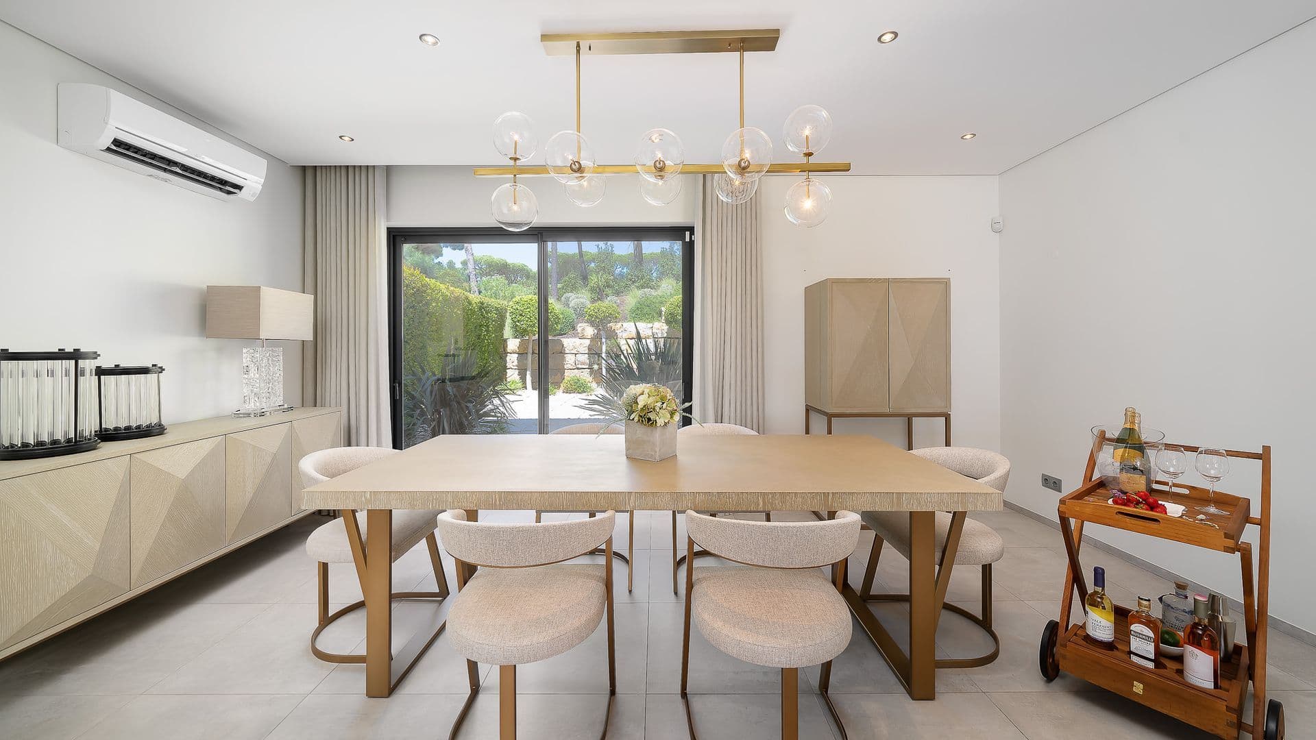 Modern dining room with a wood table and drinks trolley beside the kitchen