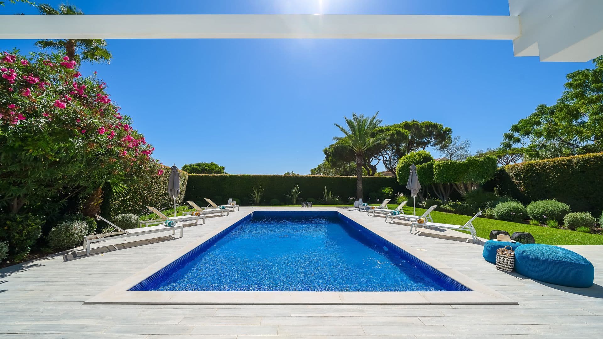 Panoramic view of the pool terrace bordered by bougainvillea and clipped hedges
