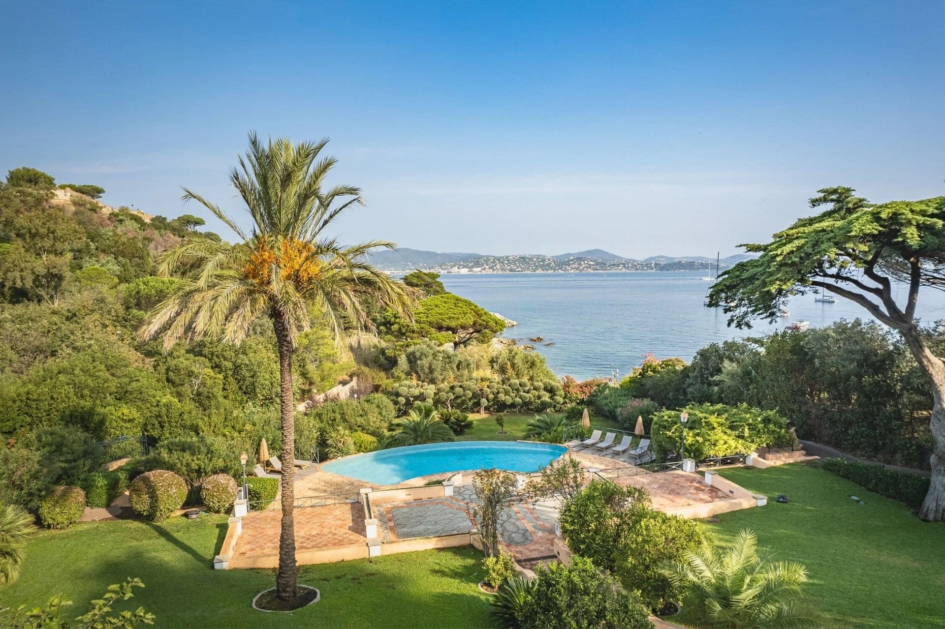Aerial view of the pool, palm-lined gardens and sea beyond at South Sea Bliss