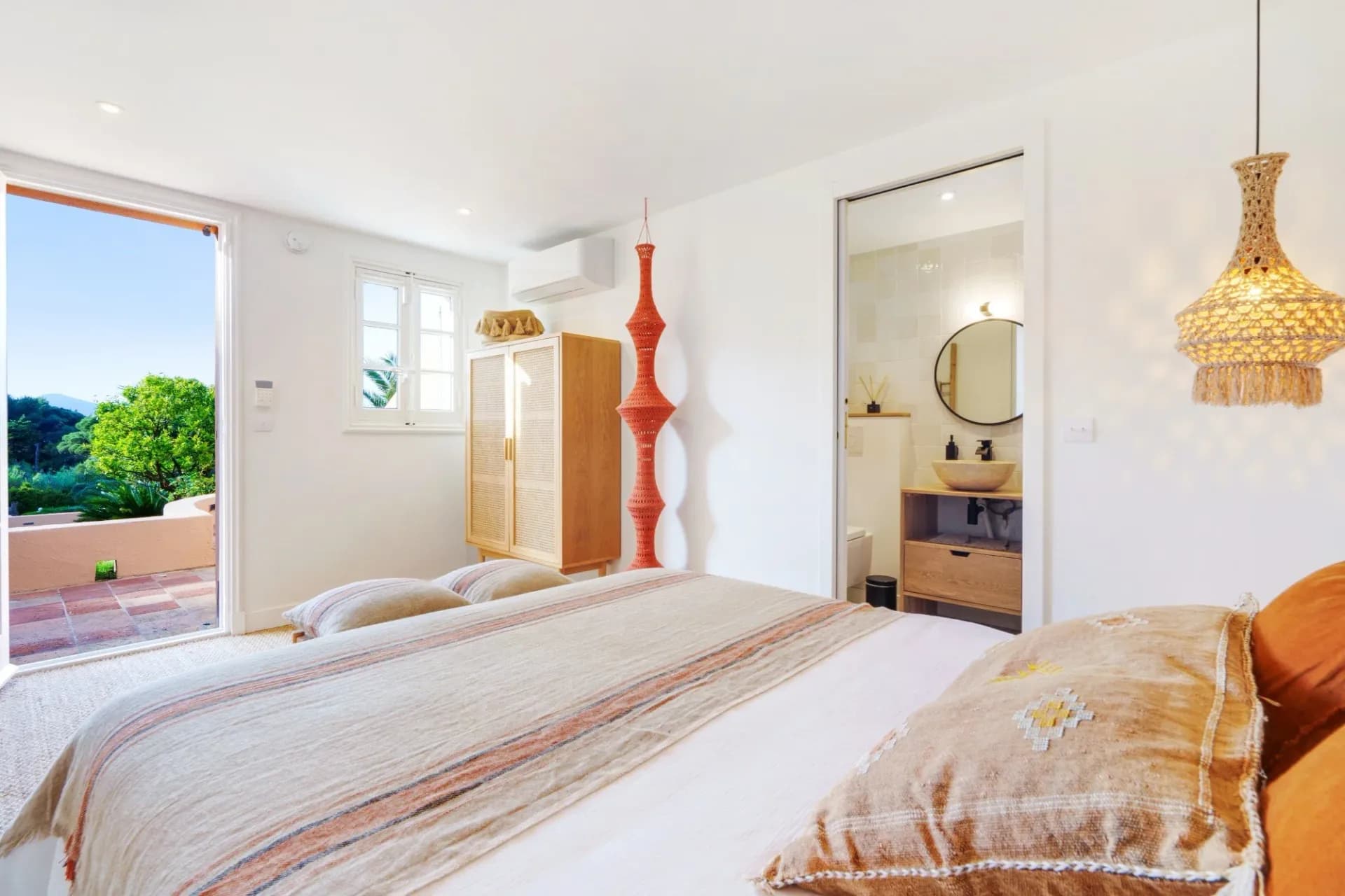 Bedroom with white linens and orange decorative accents at South Sea Bliss