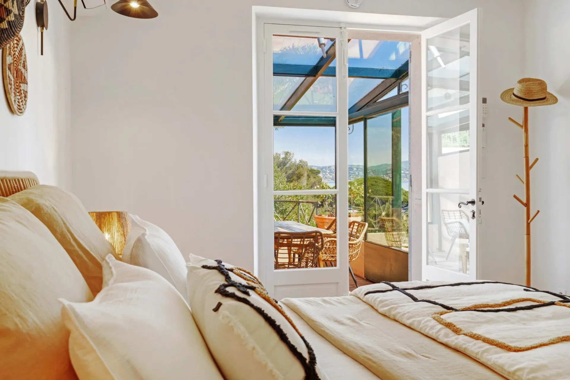 Bedroom in cream tones with glass doors opening to a terrace at South Sea Bliss