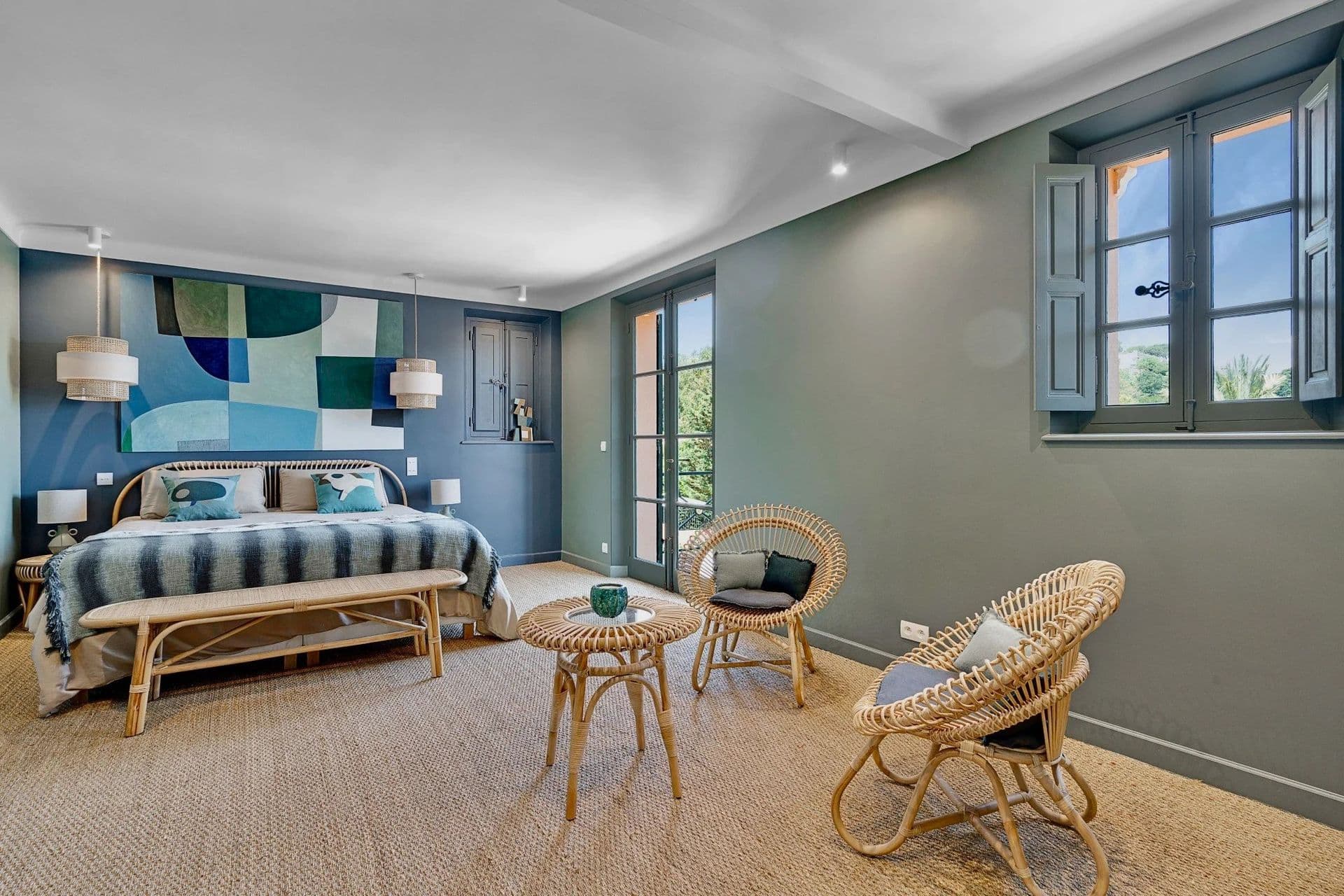 Bedroom with a patchwork blue headboard and rattan chair at South Sea Bliss