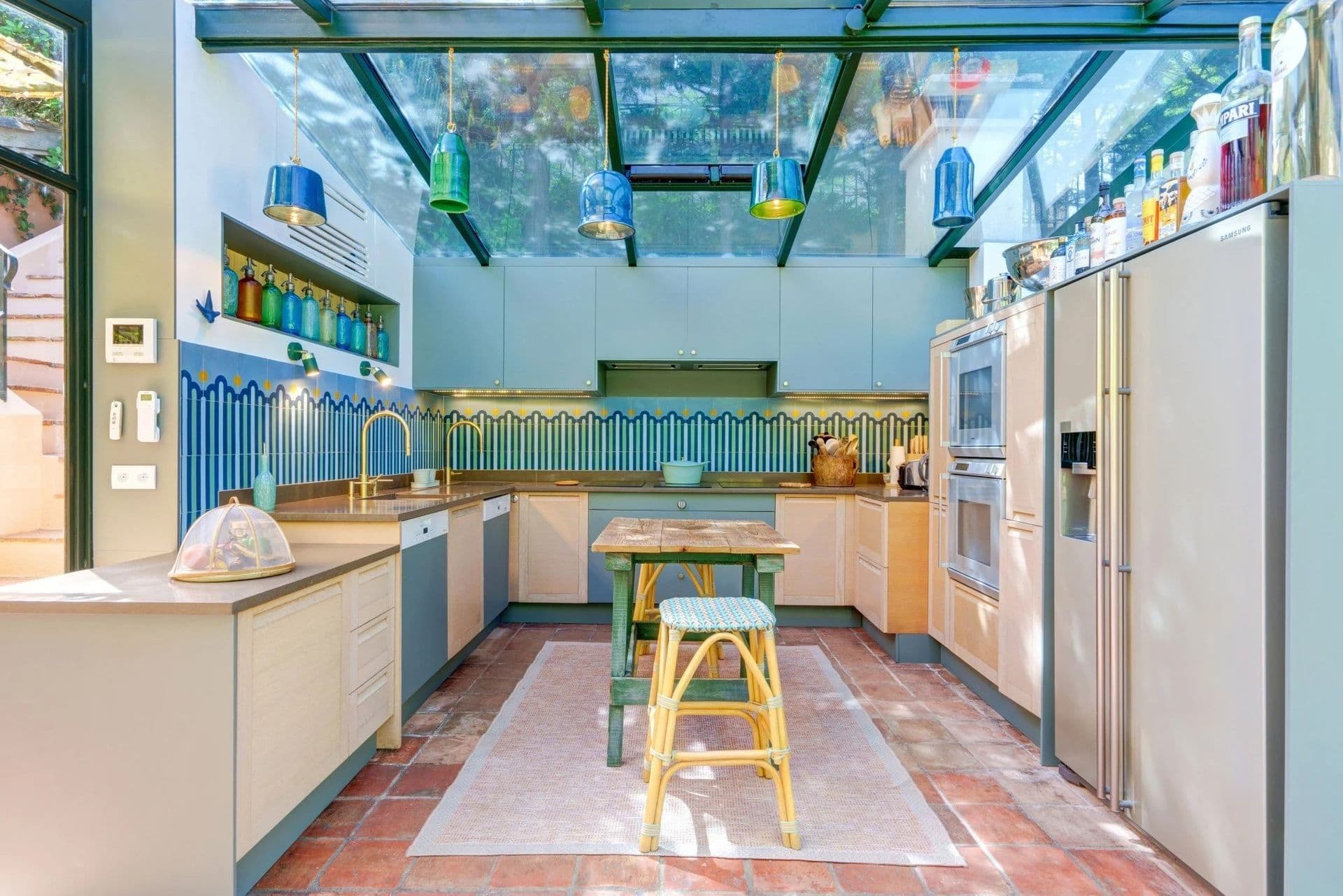 Kitchen with blue tiling and a glass conservatory roof at South Sea Bliss