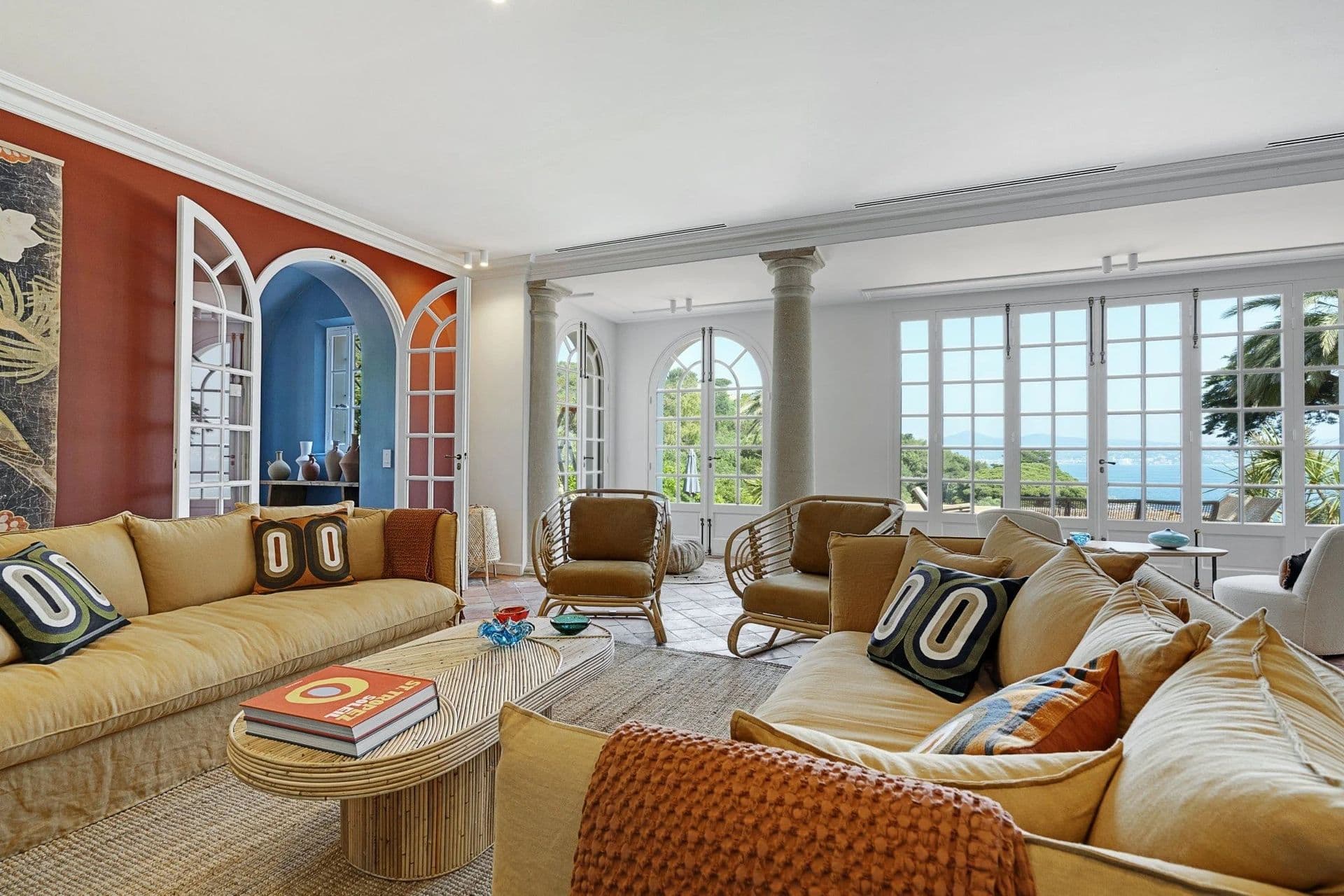 Living room with terracotta walls, columns and garden views at South Sea Bliss