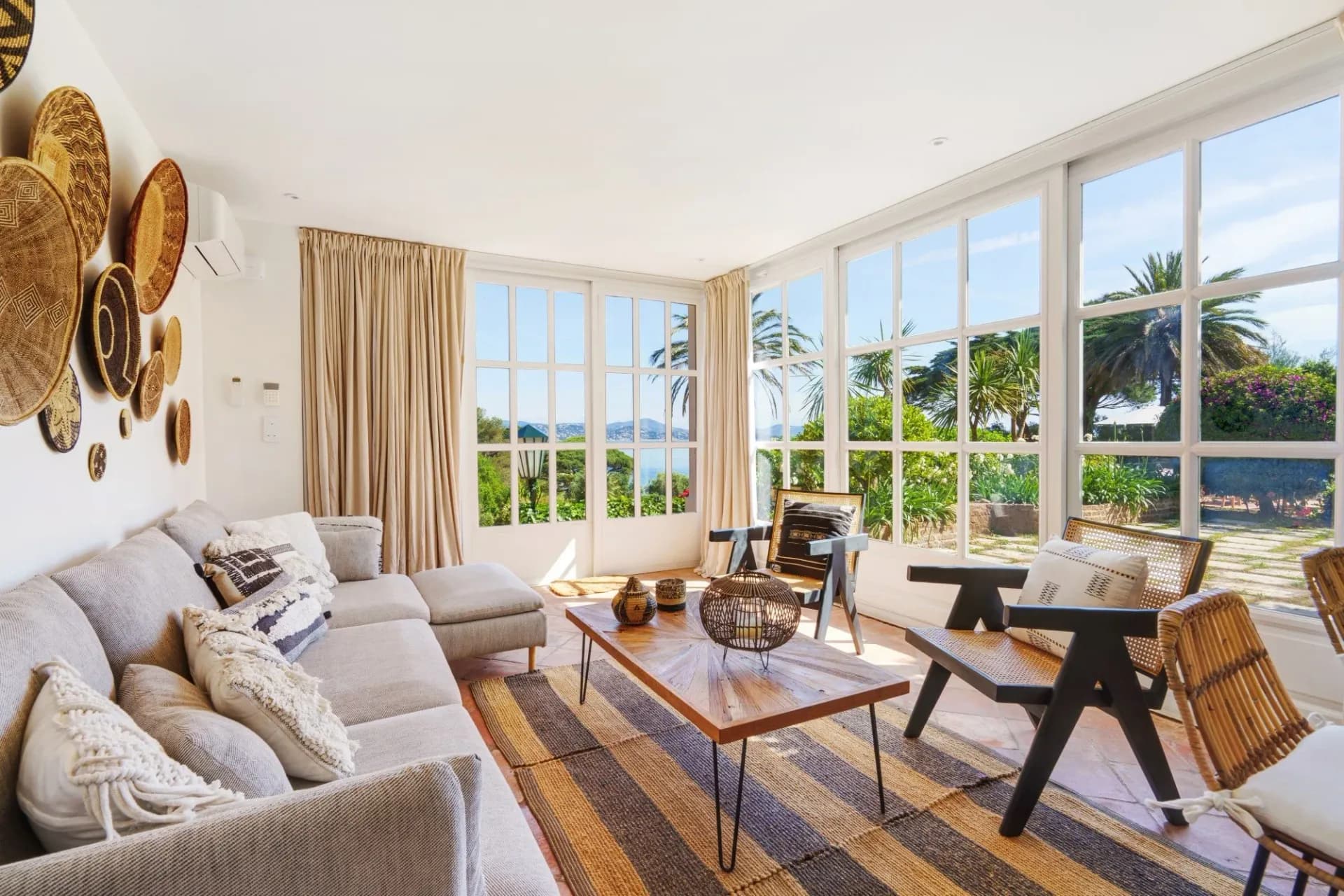 Neutral-toned living room with woven basket wall display at South Sea Bliss