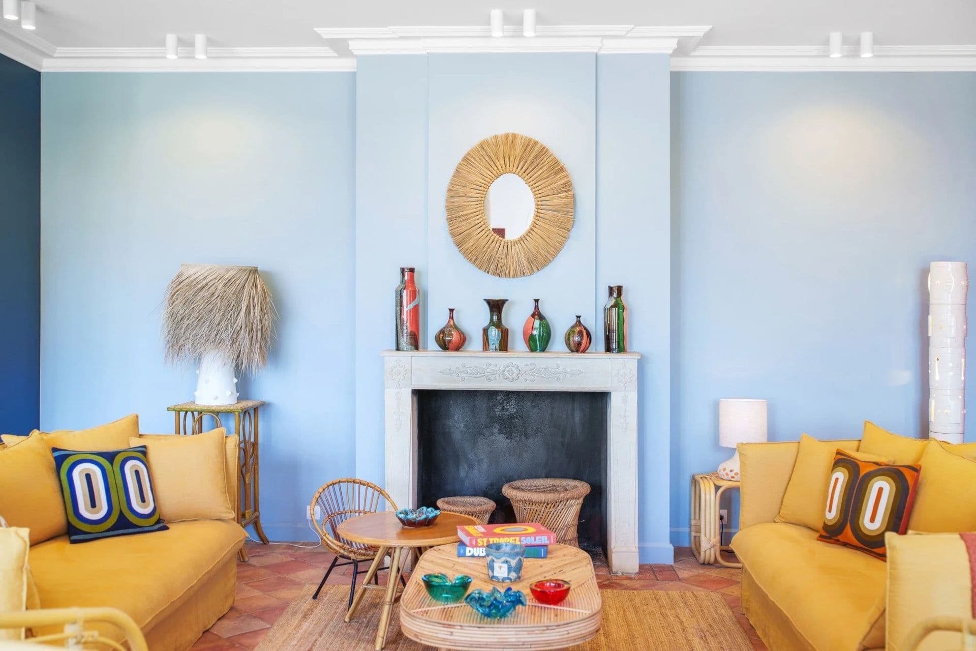 Pale blue living room with a mantel fireplace and mirror at South Sea Bliss