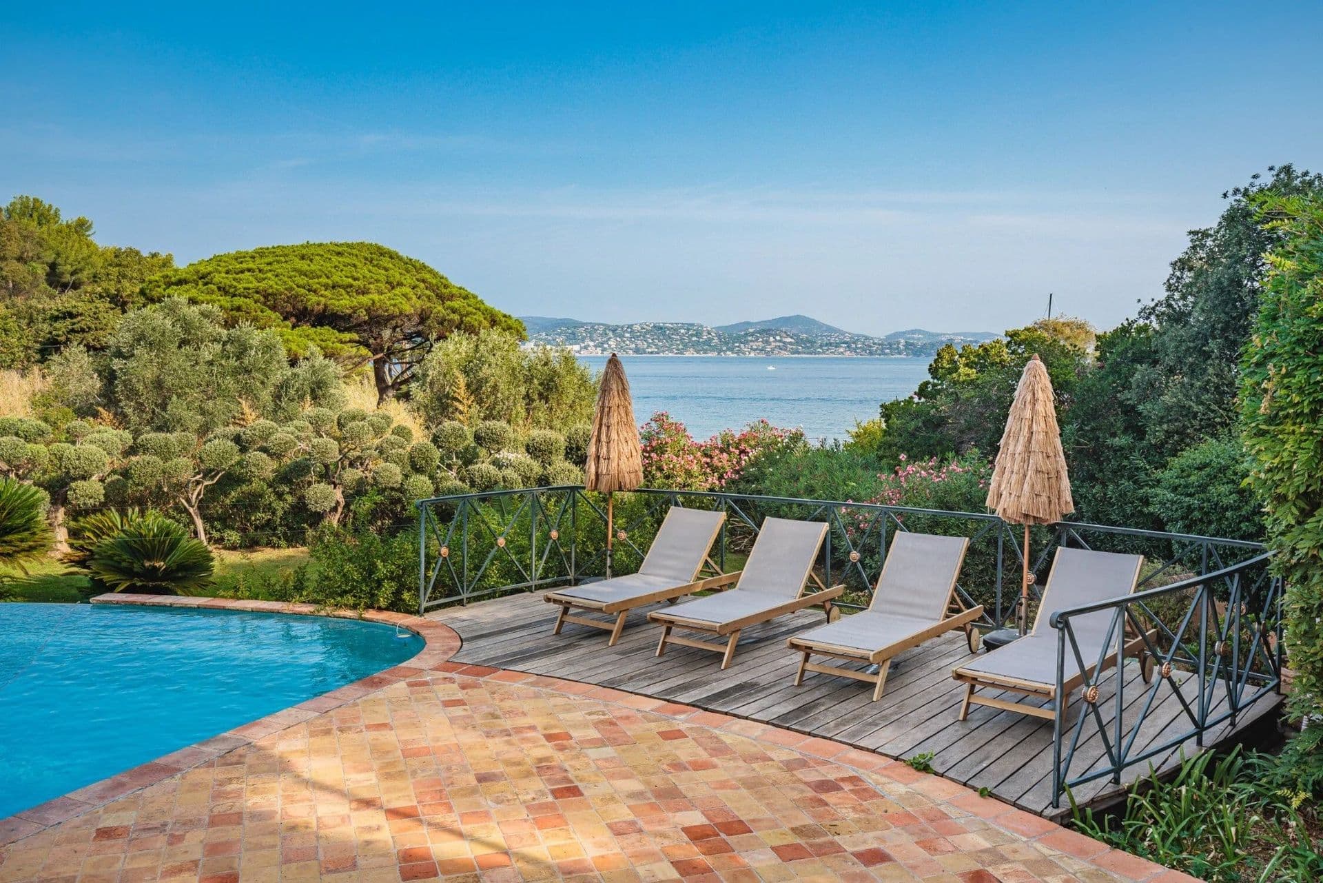 Poolside terrace with loungers overlooking the sea at South Sea Bliss
