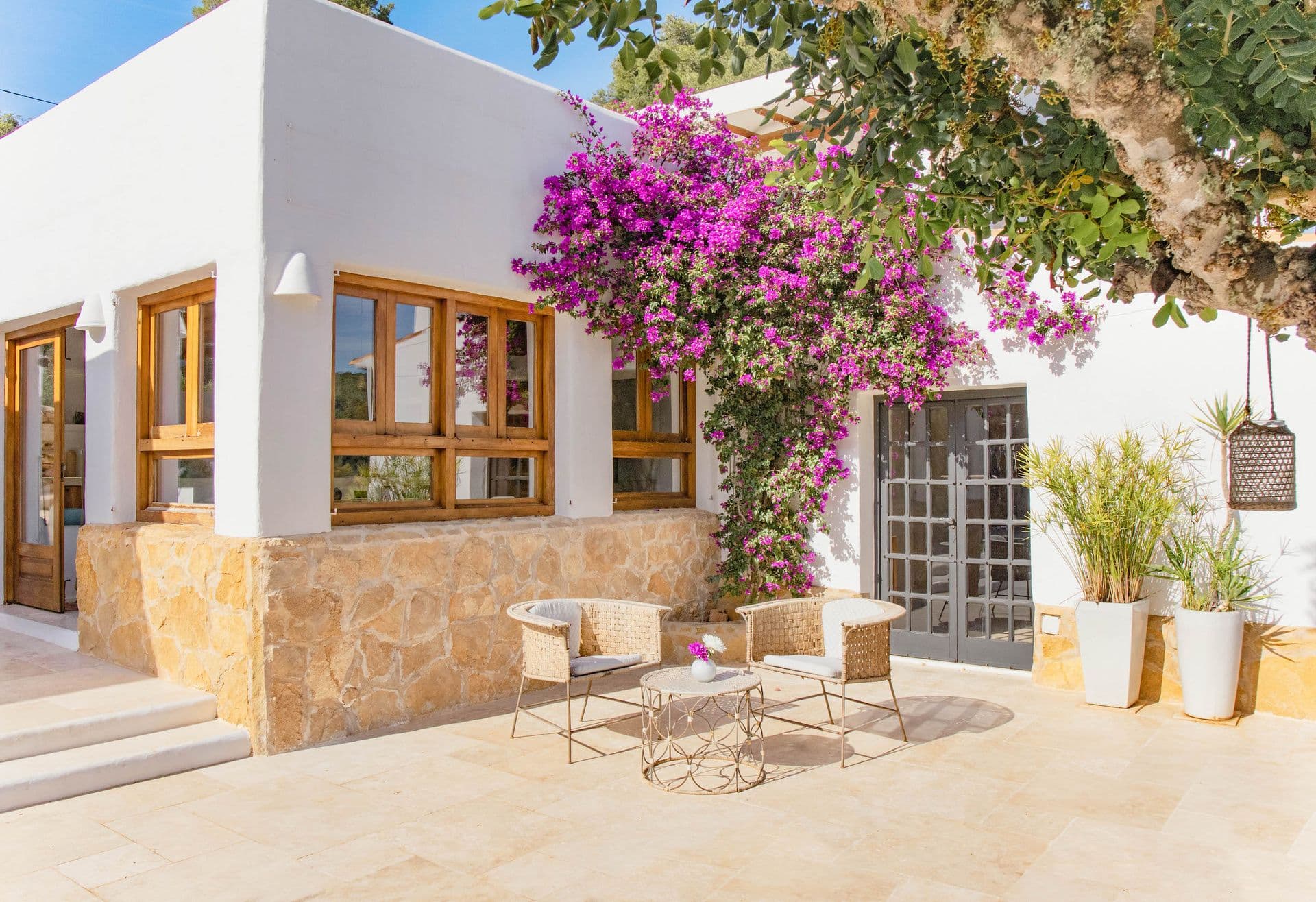 Whitewashed facade with wooden shutters and flowering bougainvillea