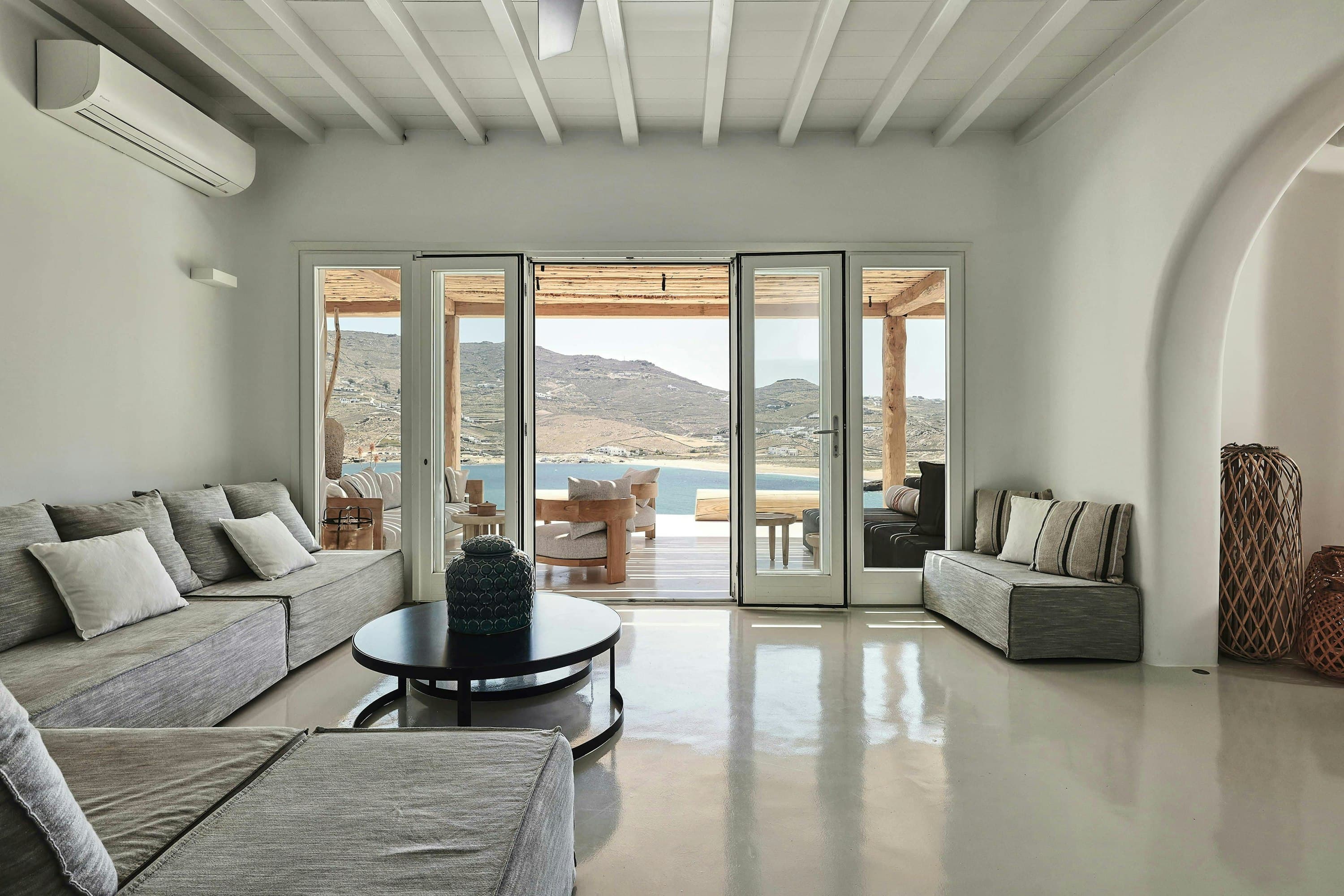Sunshine Melody living room with glass doors opening to pool terrace, Mykonos, Greece