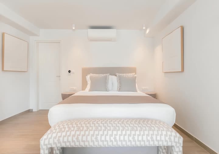 My Aegean Gem master bedroom with king bed and warm wood floors, Ornos, Cyclades Islands, Greece