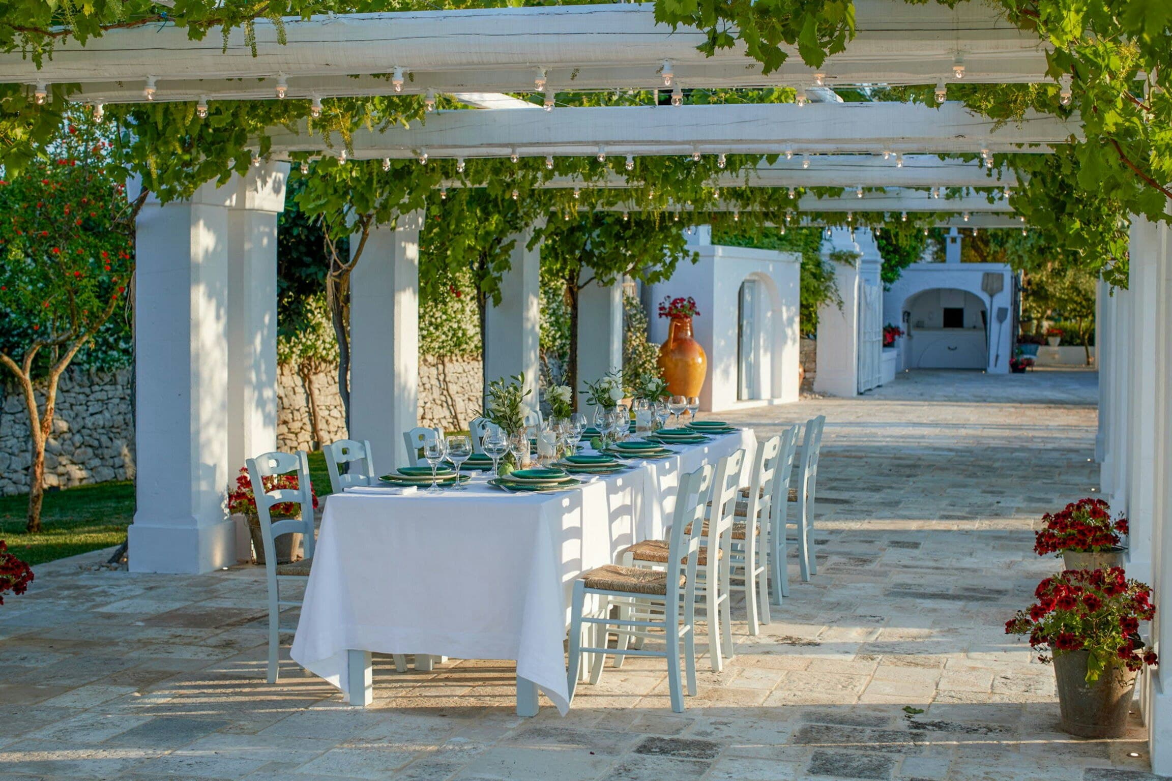 Mediterranean Sunhouse outdoor dining pergola with white furnishings, Polignano a Mare, Puglia, Italy