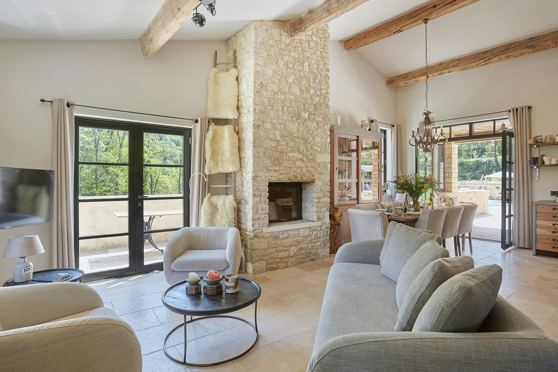 A Glass of Champagne living room with stone fireplace and beams, Ménerbes, Provence, France