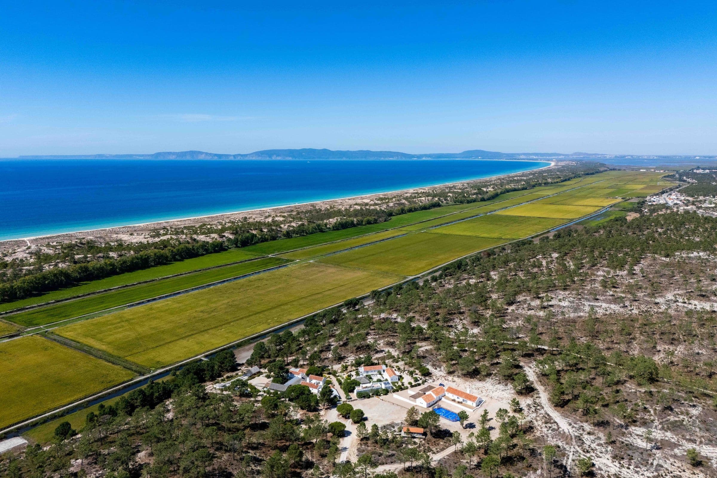 Villa Harmonia da Comporta aerial view between rice fields and coastline, Comporta, Portugal