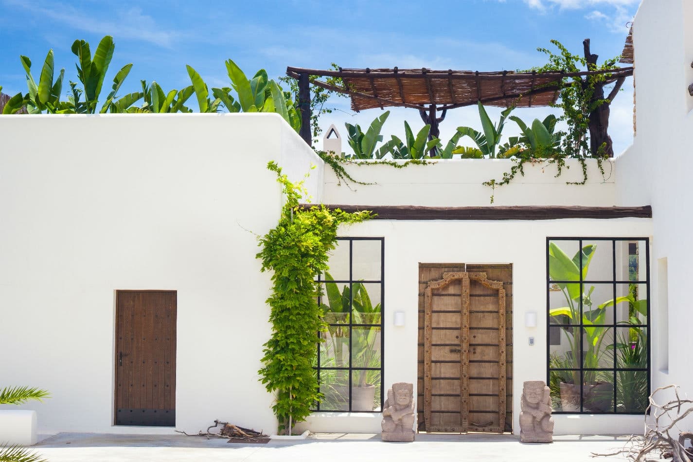 St Vetiver villa front facade with white walls and tropical gardens, Santa Eulària des Riu, Spain