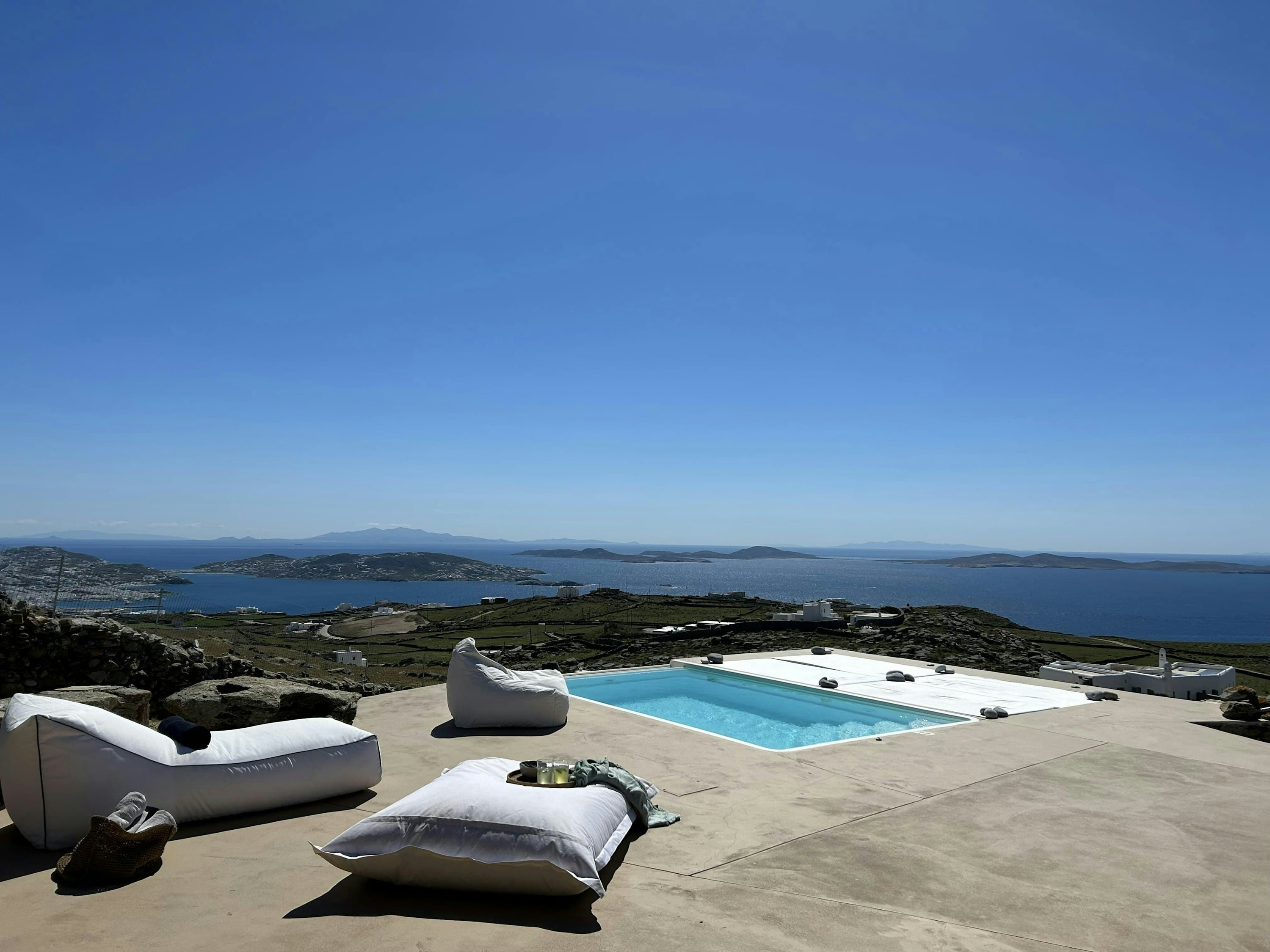 Stratos Views infinity pool with white loungers overlooking the Aegean Sea, Mykonos, Greece