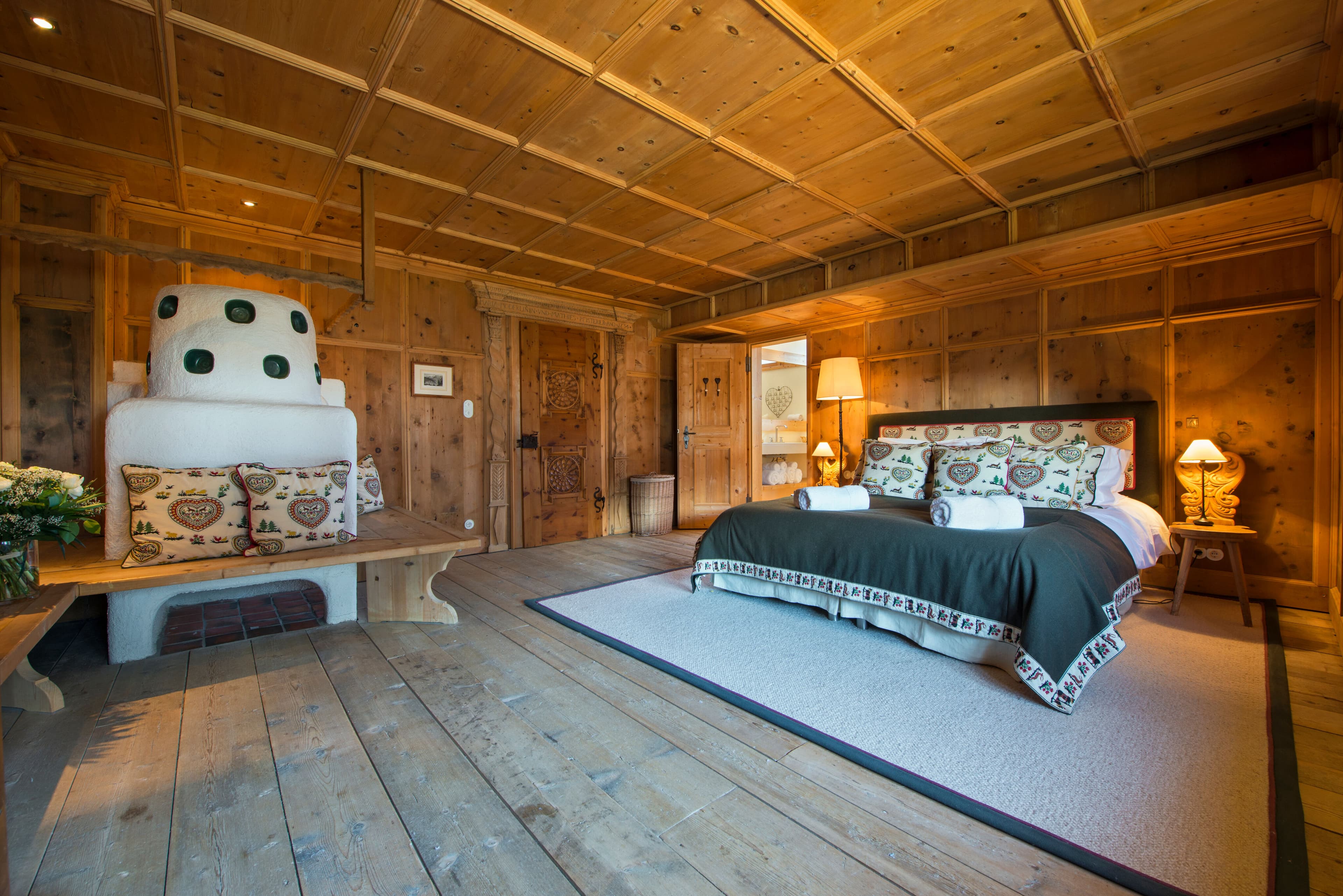 Chalet Maria Schnee traditional alpine bedroom with ceramic stove, Sankt Anton, Austria