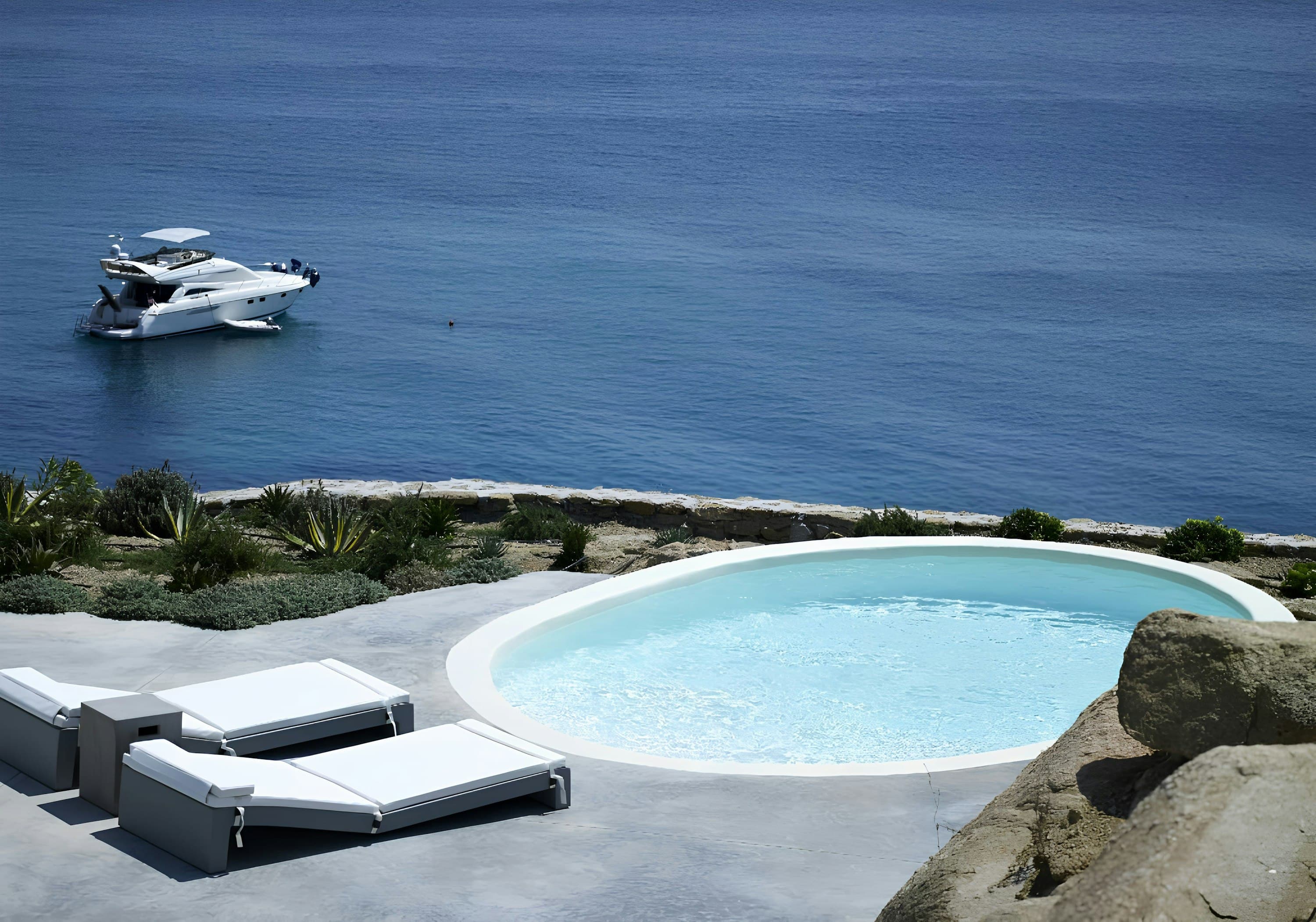 The Blue Garden curved infinity pool overlooking Aegean Sea, Platis Gialos, Cyclades Islands, Greece