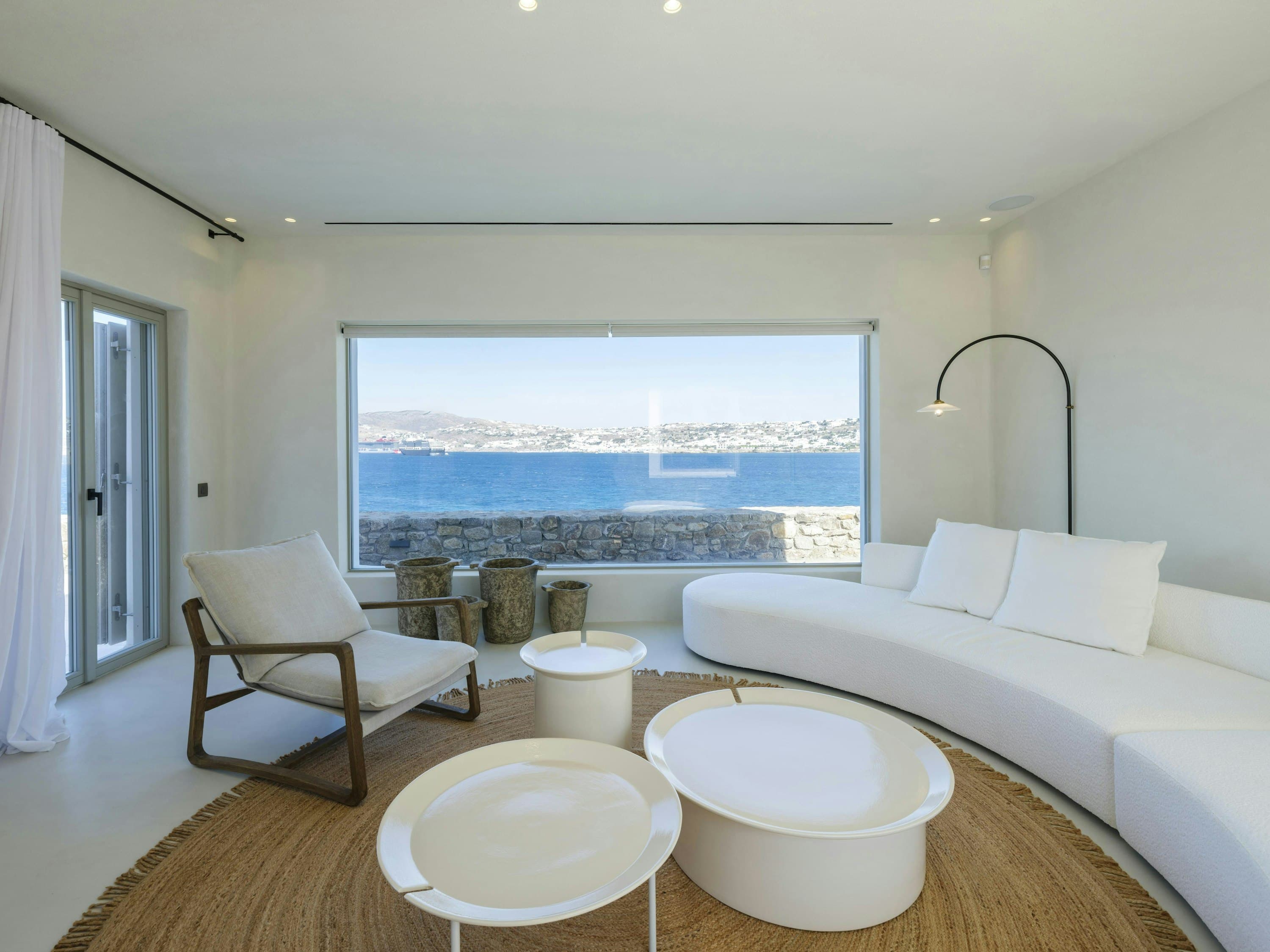 The Moon Muse living room with curved seating and ocean views, Agios Ioannis, Cyclades Islands