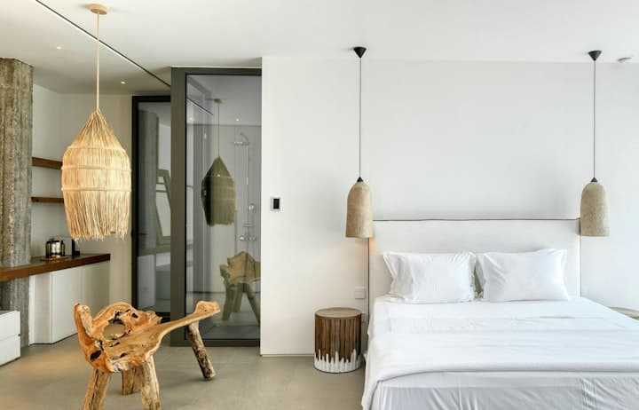 Between Stone & Sea master bedroom with white linens and natural textures, Tourlos, Cyclades Islands, Greece